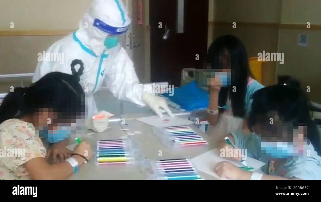 210921 -- XIANYOU, Sept. 21, 2021  -- Video image captured on Sept. 21, 2021 shows a medical worker painting with child patients who have been diagnosed with COVID-19 at an isolation ward of the Affiliated Hospital Group of Putian University in Putian, southeast China s Fujian Province. Amid the latest resurgence of COVID-19, some children have been diagnosed with the disease in Putian City. During the Mid-autumn festival, which is usually marked by family reunions, medical staff members working here played games with the child patients staying here away from their families. To make the enviro Stock Photo