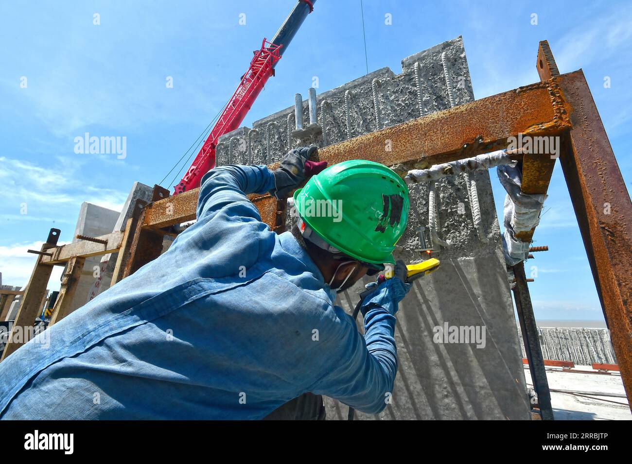 210926 -- MUNSHIGANJ, Sept. 26, 2021 -- A worker works at a construction site of Padma Multipurpose Bridge Project in Munshiganj on the outskirts of Dhaka, Bangladesh, on Sept. 12, 2021. For Bangladeshis, a dream is coming true. The history of crossing the mighty Padma river between dozens of districts in southern Bangladesh and the capital of Dhaka only by ferries or boats is all set to end. The mega multipurpose road-rail bridge dubbed the Dream Padma Bridge of Bangladesh is nearing completion after workers overcame tons of hurdles, including challenges brought by the COVID-19 pandemic. The Stock Photo