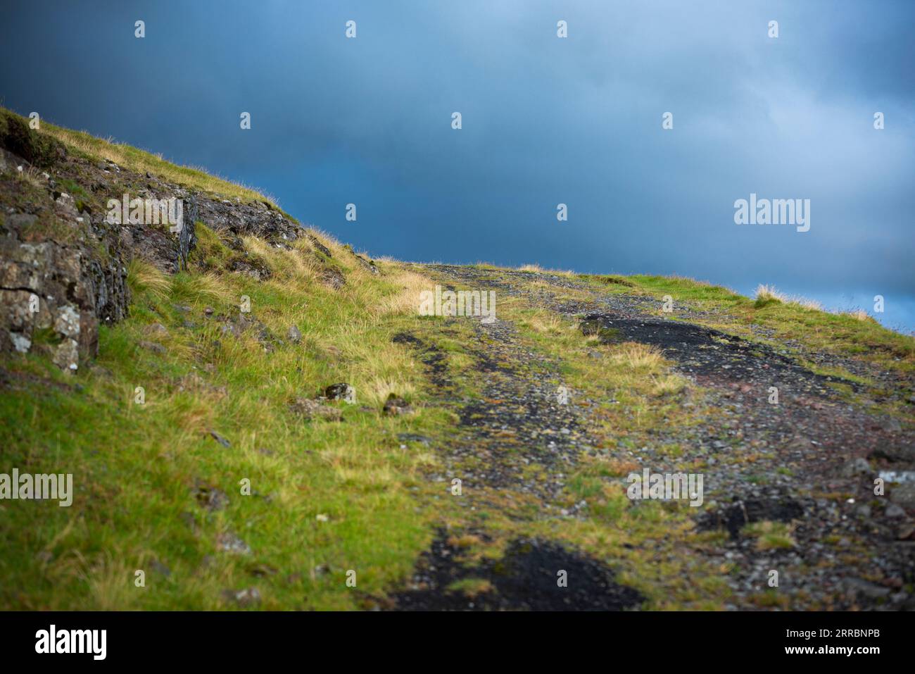Morning light bathes a mountain service road bends around a ridge on ...