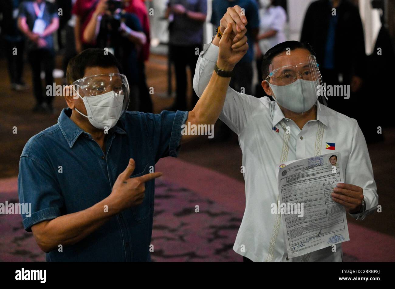 211002 -- PASAY CITY, Oct. 2, 2021 -- Philippine Senator Christopher Go R, accompanied by Philippine President Rodrigo Duterte, files his certificate of candidacy to join the vice presidential race in Pasay City, the Philippines, Oct. 2, 2021. Philippine President Rodrigo Duterte announced Saturday that he will not run for vice president in the 2022 elections and will retire from politics. Duterte was at the poll body on Saturday in Metro Manila to accompany his former longtime aide and Senator Christopher Go, 47, who filed his candidacy for vice president. /Pool via Xinhua PHILIPPINES-PASAY C Stock Photo