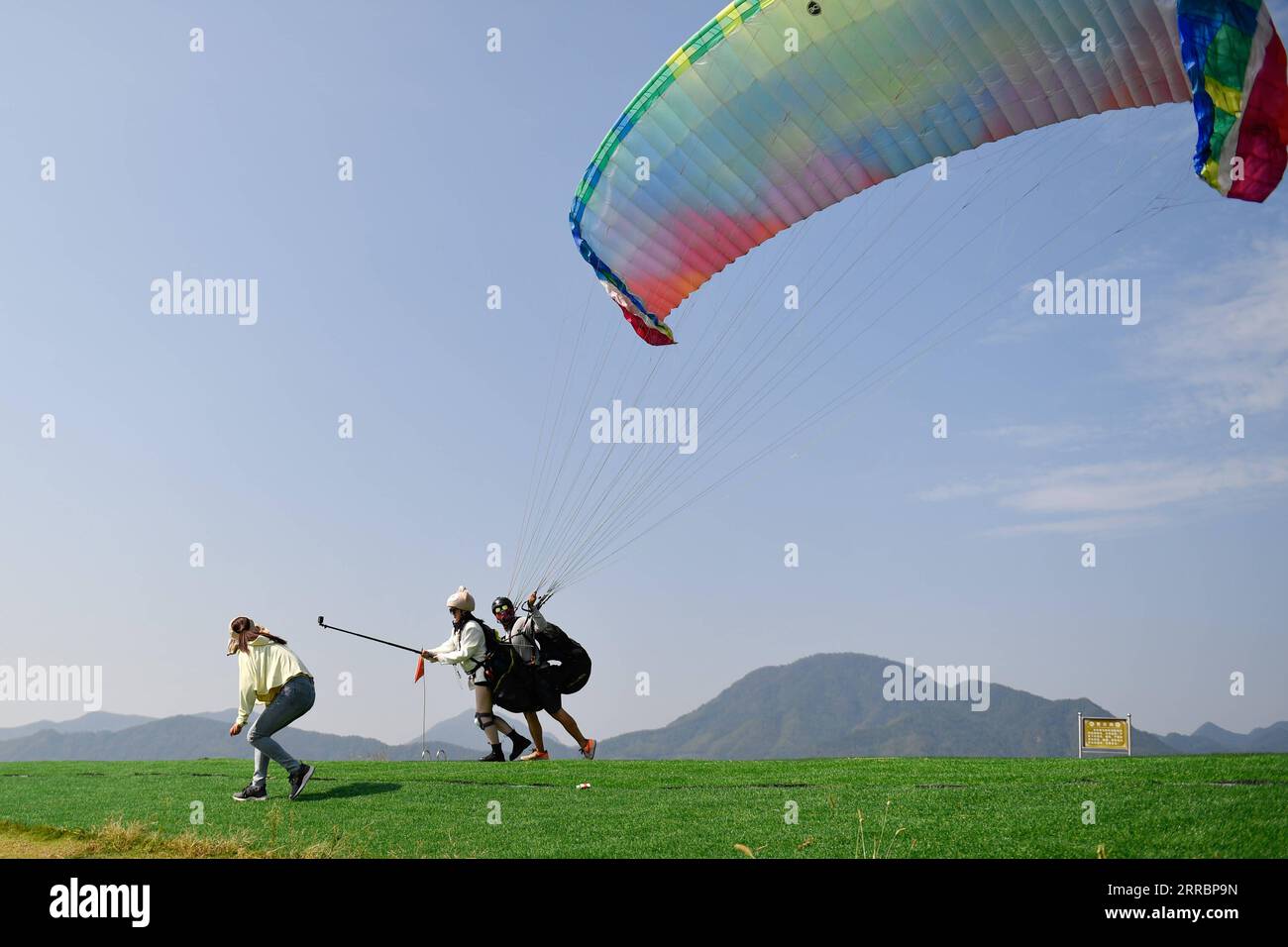 211002 -- BEIJING, Oct. 2, 2021 -- Tourists experience paragliding in Tonglu County, east China s Zhejiang Province, Oct. 2, 2021. Saturday was the second day of China s week-long National Day holiday.  CHINA-NATIONAL DAY HOLIDAY-TOURISM CN HuangxZongzhi PUBLICATIONxNOTxINxCHN Stock Photo