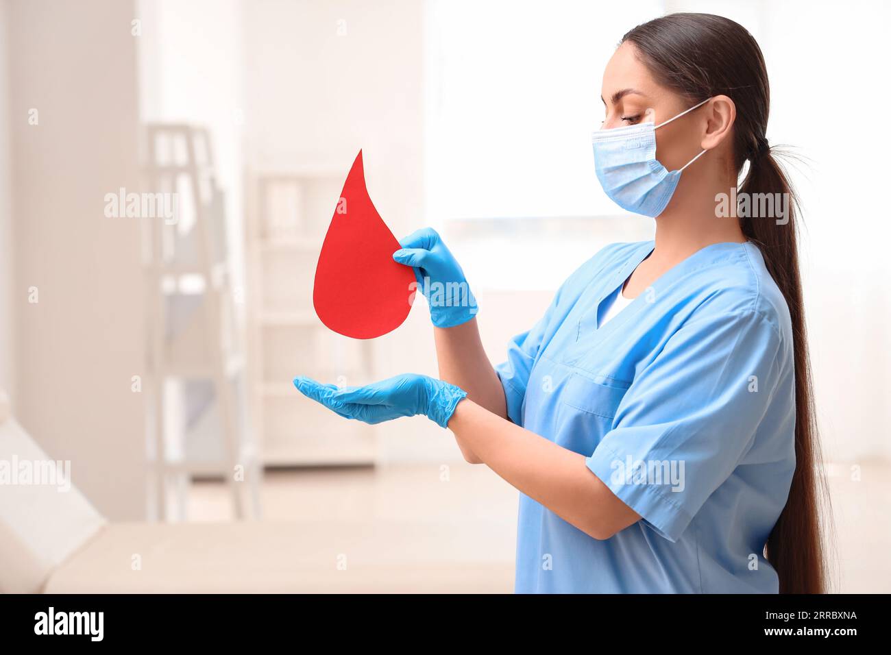 Female nurse with paper blood drop in clinic Stock Photo - Alamy