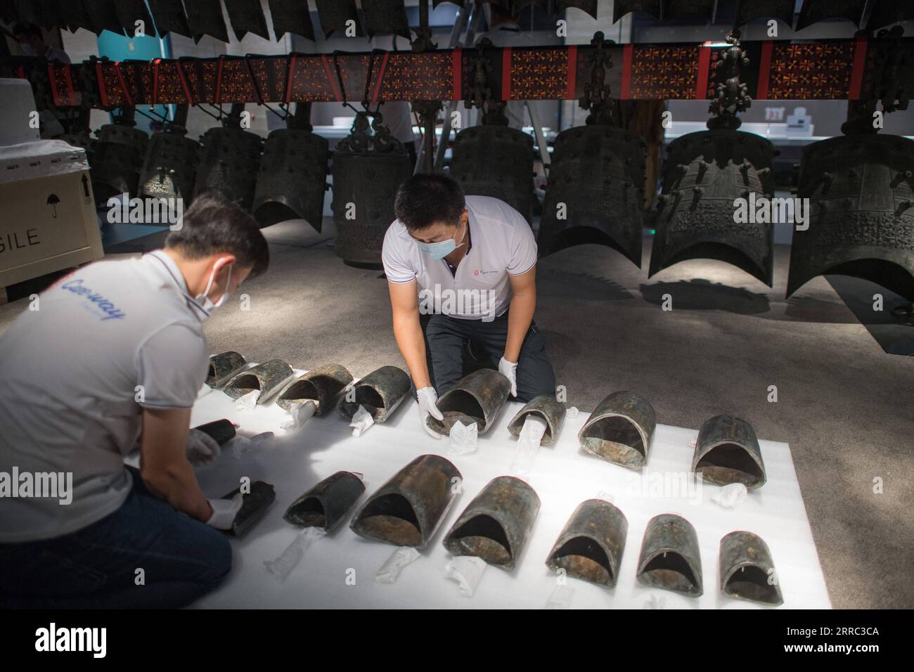 211015 -- WUHAN, Oct. 15, 2021 -- Staff members prepare to install chime bells after they were transferred to a newly-built exhibition hall of Hubei Provincial Museum in Wuhan, central China s Hubei Province, Oct. 15, 2021. The set of chime bells were recently relocated to the newly-built third phase project of the museum. Chime bell, or bian zhong in Chinese, is a percussion instrument that became prevalent in China from the Western Zhou Dynasty 1046-771 B.C.. The country s largest set of chime bells ever unearthed was found in 1978, also in Suizhou, in the tomb of Marquis Yi, a ruler of the Stock Photo