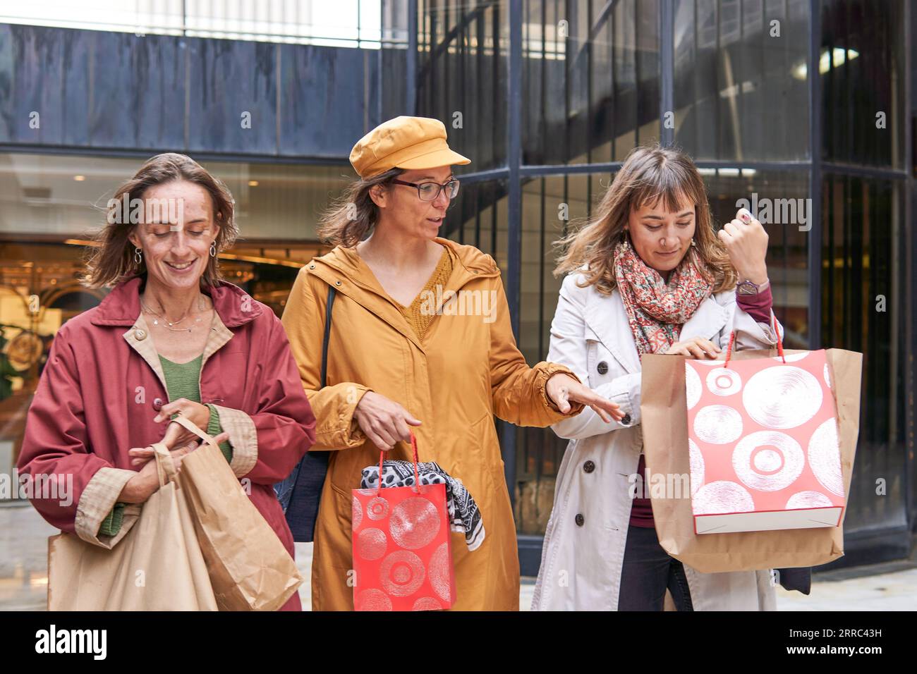 Group of mature women talking while walking on a mall after shopping day Stock Photo
