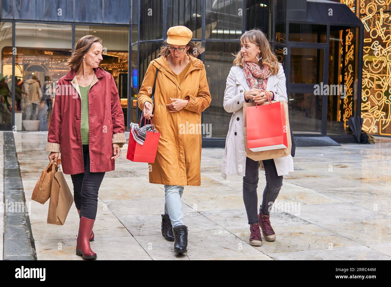 Mature women with shopping bags talking near the christmas lights Stock Photo