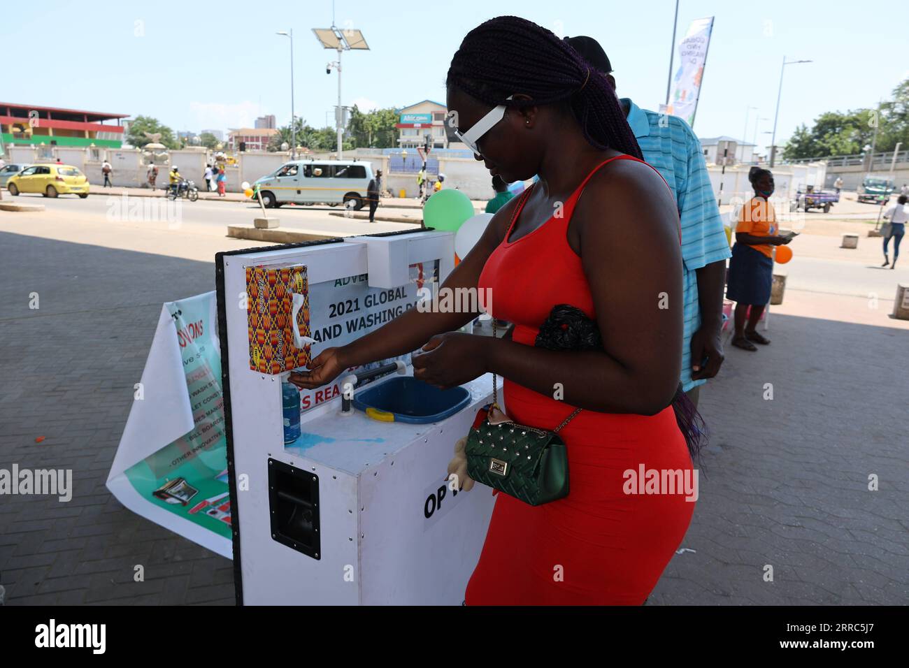 211019 -- ACCRA, Oct. 19, 2021 -- A woman uses a handwashing facility to wash her hands in Accra, Ghana, on Oct. 15, 2021. The ongoing COVID-19 pandemic that lasted for more than a year in Ghana has not only prompted citizens to care more about their hand hygiene, but spurred local inventors to come up with more creative ways to cater to people s needs for handwashing, particularly in public. TO GO WITH Feature: Ghanaian inventors bring out creative handwashing facilities to combat COVID-19  GHANA-ACCRA-COVID-19-INVENTION-WASHING FACILITY XuxZheng PUBLICATIONxNOTxINxCHN Stock Photo