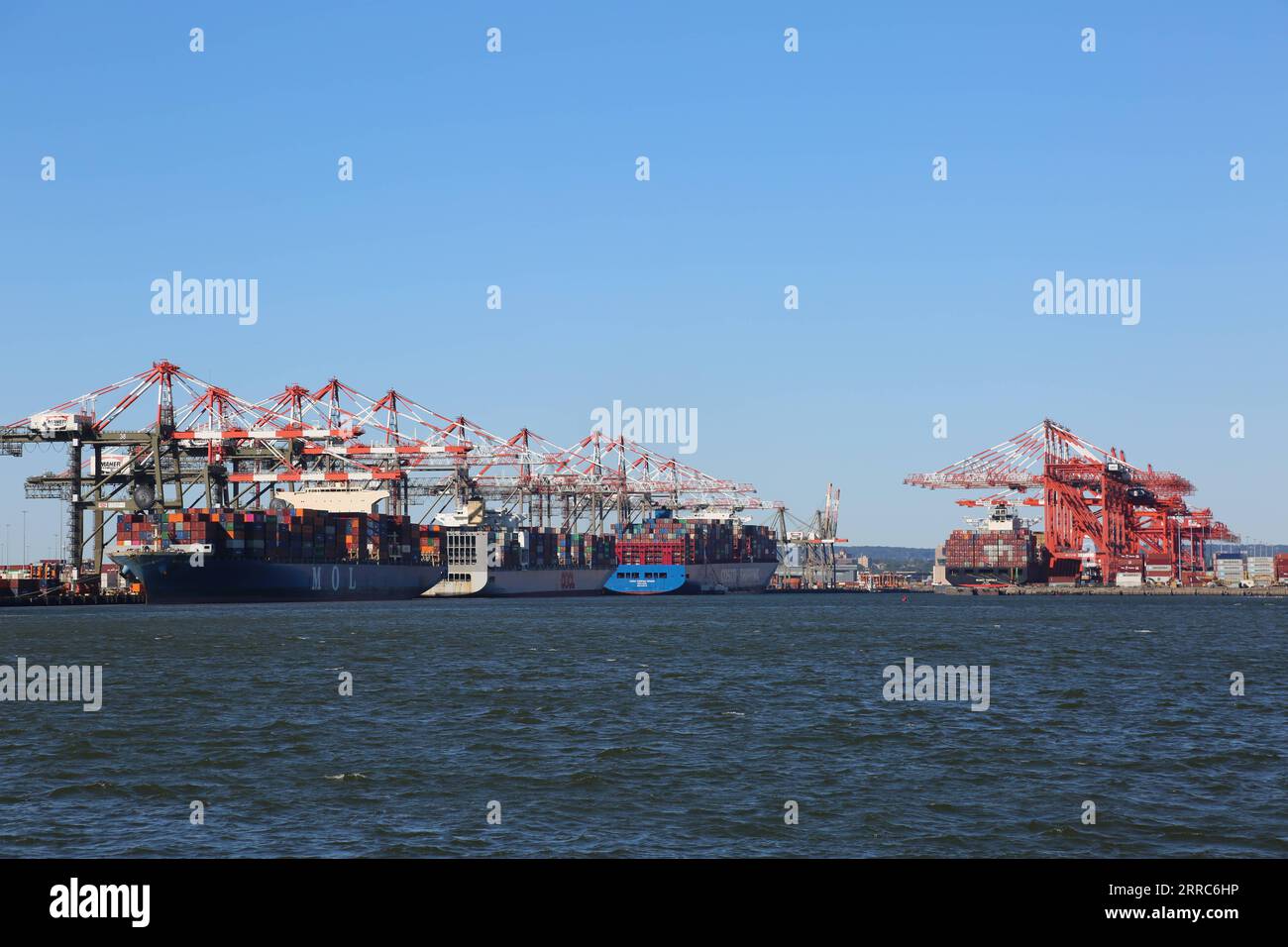 211020 -- BAYONNE U.S., Oct. 20, 2021 -- Containers are seen in the process of logistics operations at Port Newark Container Terminal and Maher Terminal owned by the Port Authority of New York and New Jersey in Bayonne, New Jersey, the United States, on Oct. 19, 2021. The United States has been plagued by supply chain disruptions in recent months, and the White House has asked the Port of Los Angeles to become a 24-hour port, open seven days a week. However, with the approach of holidays, which will see surging demand across the country, the shipping-based supply chain remains under stress.  T Stock Photo