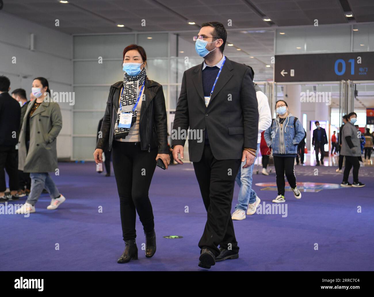 211022 -- TIANJIN, Oct. 22, 2021 -- Italian wine merchant Candido Mormile walks with his wife during the 105th China Food & Drinks Fair in the national convention and exhibition center in Tianjin, north China, Oct. 20, 2021. Candido Mormile, an owner and founder of a wineries association from Italy, Lunanera Italian winery association, gets a good result and meets new cooperations in the 105th China Food & Drinks Fair. The fair kicked off on Tuesday in Tianjin Municipality, attracting more than 3,000 exhibitors.  CHINA-TIANJIN-ITALIAN WINE MERCHANT CN SunxFanyue PUBLICATIONxNOTxINxCHN Stock Photo