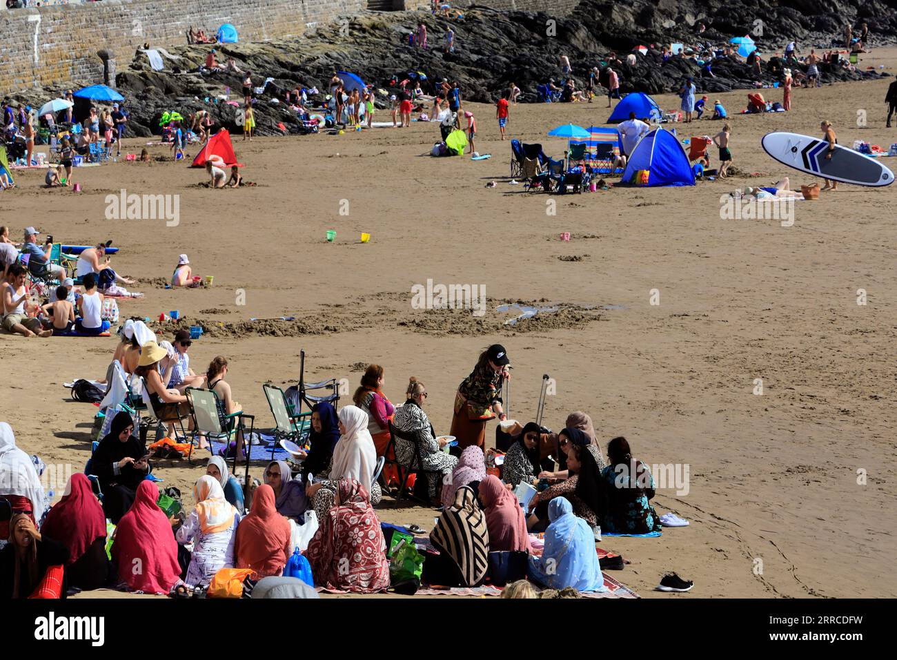 Ethnic minority women picnicking on Barry Island beach enjoying the hottest day of the year. Sept 2023. Stock Photo