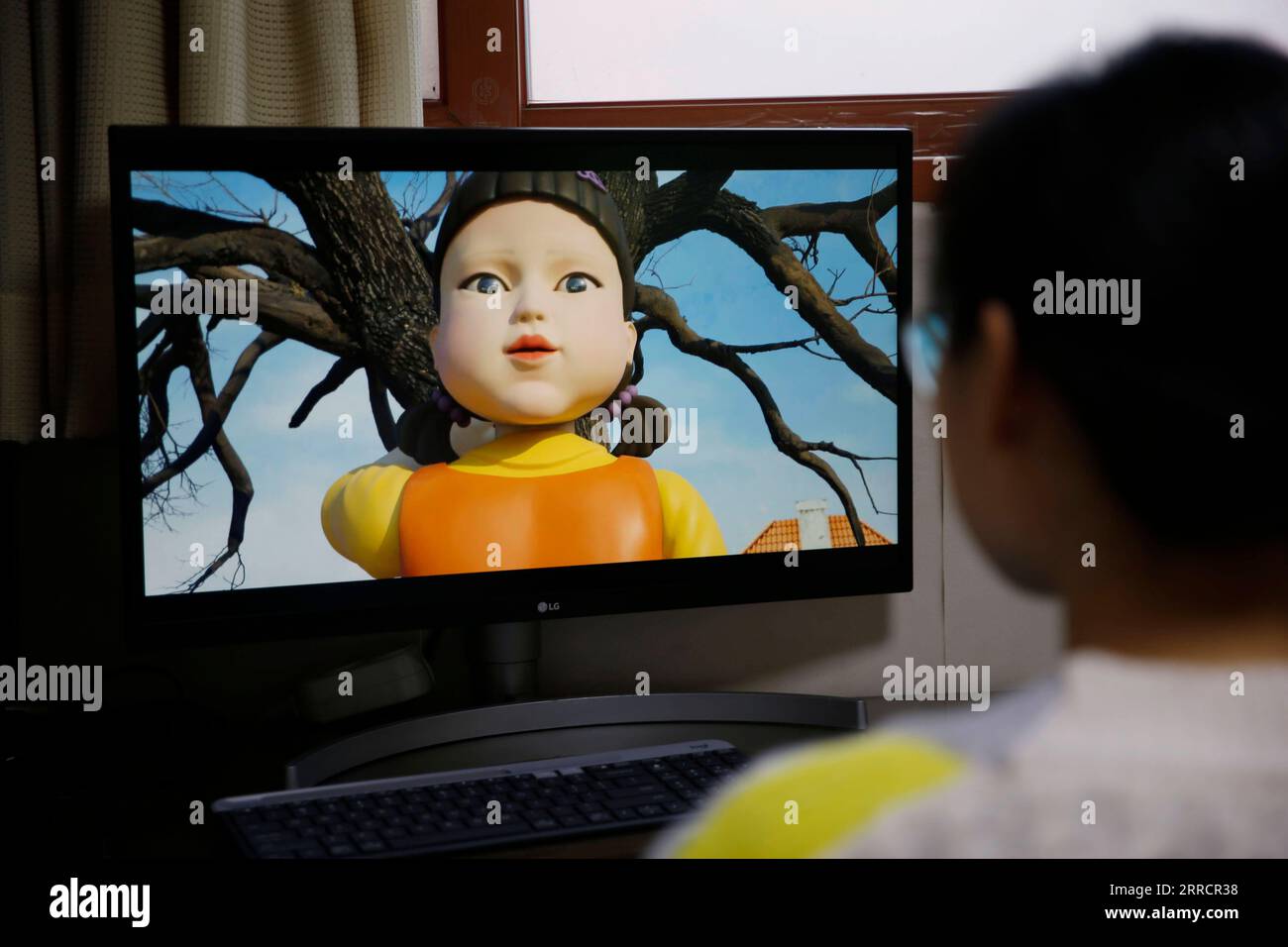 211115 -- SEOUL, Nov. 15, 2021 -- A person watches the South Korean drama Squid Game at home in Seoul, South Korea, Nov. 15, 2021. The South Korean drama Squid Game has drawn worldwide attention as it vividly depicts the cruelty of capitalistic society through children s games played by a group of debt-ridden underdogs for money. The dystopian drama, which debuted on Netflix on Sept. 17, attracted over 111 million views in less than four weeks, becoming the streaming service s most-watched series.  SOUTH KOREA-SEOUL-SQUID GAME WangxYiliang PUBLICATIONxNOTxINxCHN Stock Photo