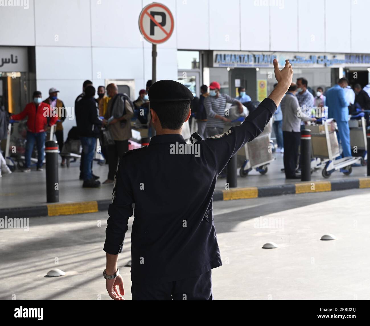 211128 -- FARWANIYA GOVERNORATE, Nov. 28, 2021 -- A police officer organizes traffic outside the departure hall of Kuwait International Airport in Farwaniya Governorate, Kuwait, Nov. 28, 2021. Kuwait decided on Saturday to suspend direct flights with nine African countries, including South Africa, over the new COVID-19 variant Omicron. Photo by /Xinhua KUWAIT-FARWANIYA GOVERNORATE-COVID-19-AFRICAN COUNTRIES-FLIGHTS-SUSPENSION Asad PUBLICATIONxNOTxINxCHN Stock Photo