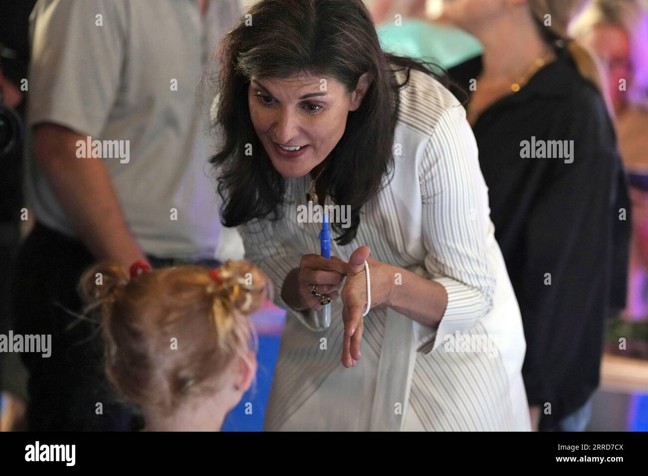 Republican presidential hopeful Nikki Haley puts on a bracelet given to