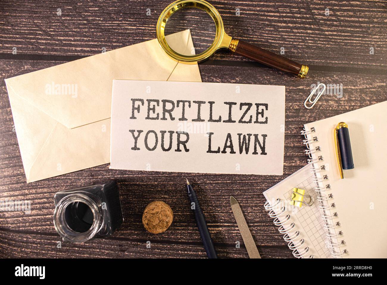 Sign on a green lawn - Fertilize your lawn Stock Photo - Alamy