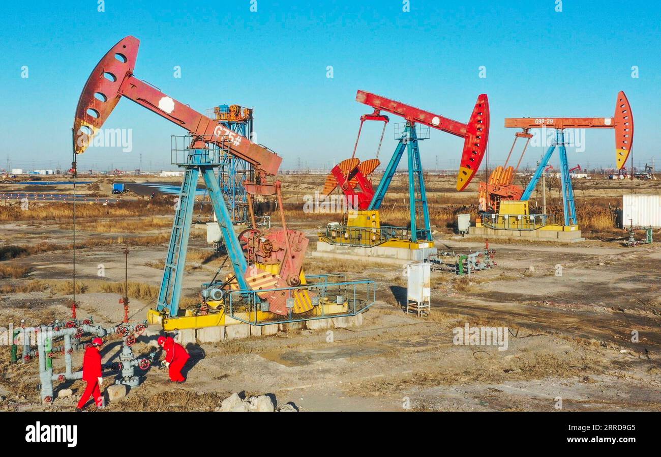 211212 -- TANGSHAN, Dec. 12, 2021 -- Aerial photo taken on Dec. 12, 2021 shows workers inspecting an oil well at Jidong Oilfield in north China s Hebei Province. Since entering winter, workers at Jidong Oilfield have overcome the unfavorable factors of winter production and strengthened daily inspection to ensure the completion of annual production targets. Photo by /Xinhua CHINA-HEBEI-JIDONG OILFIELD CN LiuxMancang PUBLICATIONxNOTxINxCHN Stock Photo