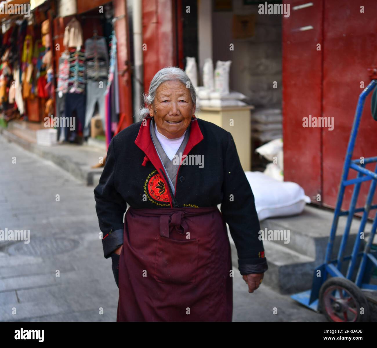 211213 -- LHASA, Dec. 13, 2021 -- Migmar Tsamjo walks on the street in Lhasa, southwest China s Tibet Autonomous Region, Dec. 7, 2021. Migmar Tsamjo was born in 1933. She herded cattle for the serf owner and lived a miserable life in childhood. She fled from the serf owner in 1955, and was later rescued by the People s Liberation Army. She then was sent to Chengdu in southwest China s Sichuan Province and began to study at a college. In 1959, democratic reform was launched and feudal serfdom was finally abolished in Tibet. A million serfs and slaves were emancipated. Recalling bitter days of t Stock Photo