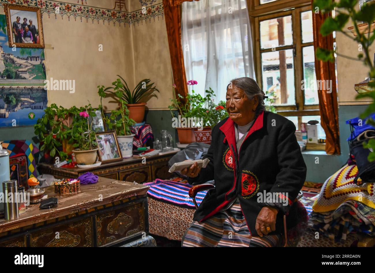 211213 -- LHASA, Dec. 13, 2021 -- Migmar Tsamjo watches TV at her house in Lhasa, southwest China s Tibet Autonomous Region, Dec. 7, 2021. Migmar Tsamjo was born in 1933. She herded cattle for the serf owner and lived a miserable life in childhood. She fled from the serf owner in 1955, and was later rescued by the People s Liberation Army. She then was sent to Chengdu in southwest China s Sichuan Province and began to study at a college. In 1959, democratic reform was launched and feudal serfdom was finally abolished in Tibet. A million serfs and slaves were emancipated. Recalling bitter days Stock Photo