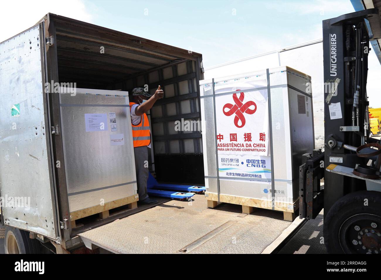 211214 -- MAPUTO, Dec. 14, 2021 -- A staff member transfers the new batch of COVID-19 Sinopharm vaccines donated by China at the Maputo International Airport in Maputo, Mozambique, Dec. 12, 2021. Another batch of COVID-19 Sinopharm vaccines donated by China has arrived in Mozambique to help the African country better deal with the pandemic.  MOZAMBIQUE-MAPUTO-CHINA-DONATED VACCINES-ARRIVAL NiexZuguo PUBLICATIONxNOTxINxCHN Stock Photo
