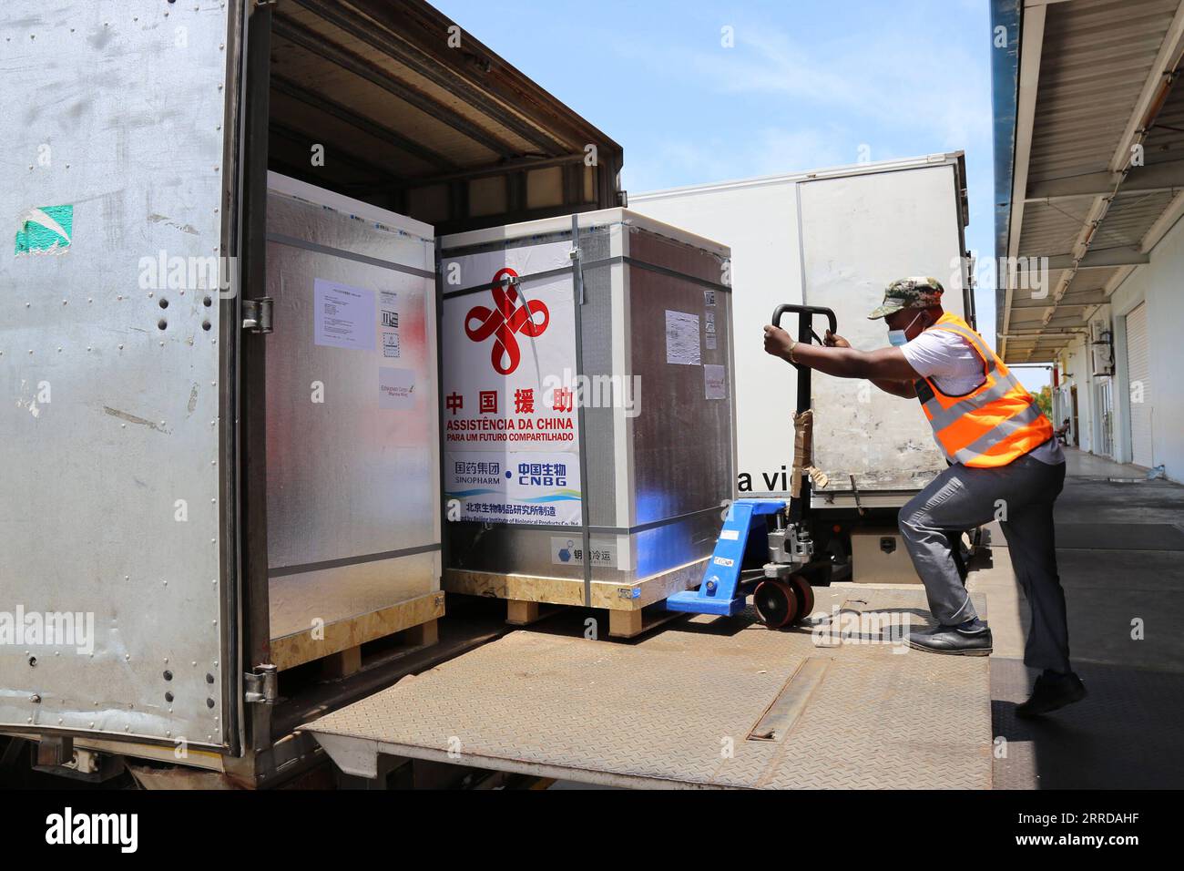 211214 -- MAPUTO, Dec. 14, 2021 -- A staff member transfers the new batch of COVID-19 Sinopharm vaccines donated by China at the Maputo International Airport in Maputo, Mozambique, Dec. 12, 2021. Another batch of COVID-19 Sinopharm vaccines donated by China has arrived in Mozambique to help the African country better deal with the pandemic.  MOZAMBIQUE-MAPUTO-CHINA-DONATED VACCINES-ARRIVAL NiexZuguo PUBLICATIONxNOTxINxCHN Stock Photo