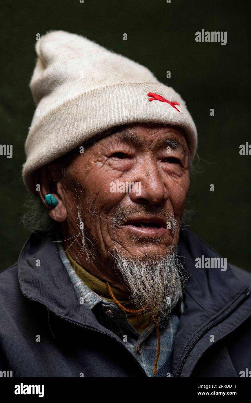 211219 -- LHASA, Dec. 19, 2021 -- Tsering Dondrup poses for a portrait in southwest China s Tibet Autonomous Region, May 13, 2021. Born in 1947, Tsering Dondrup lives in Jianggang Village, Nyalam County of Tibet. Tsering and his family members served as enslaved farmers for their serf owner in old Tibet. Drudgeries including farming, collecting firewood and cow dung fell on them with little rations could be earned from serf owner. When it came to harvest, the ripe highland barley they had planted were claimed by serf owner. If we show any sluggishness during work, the serf owner would hit our Stock Photo