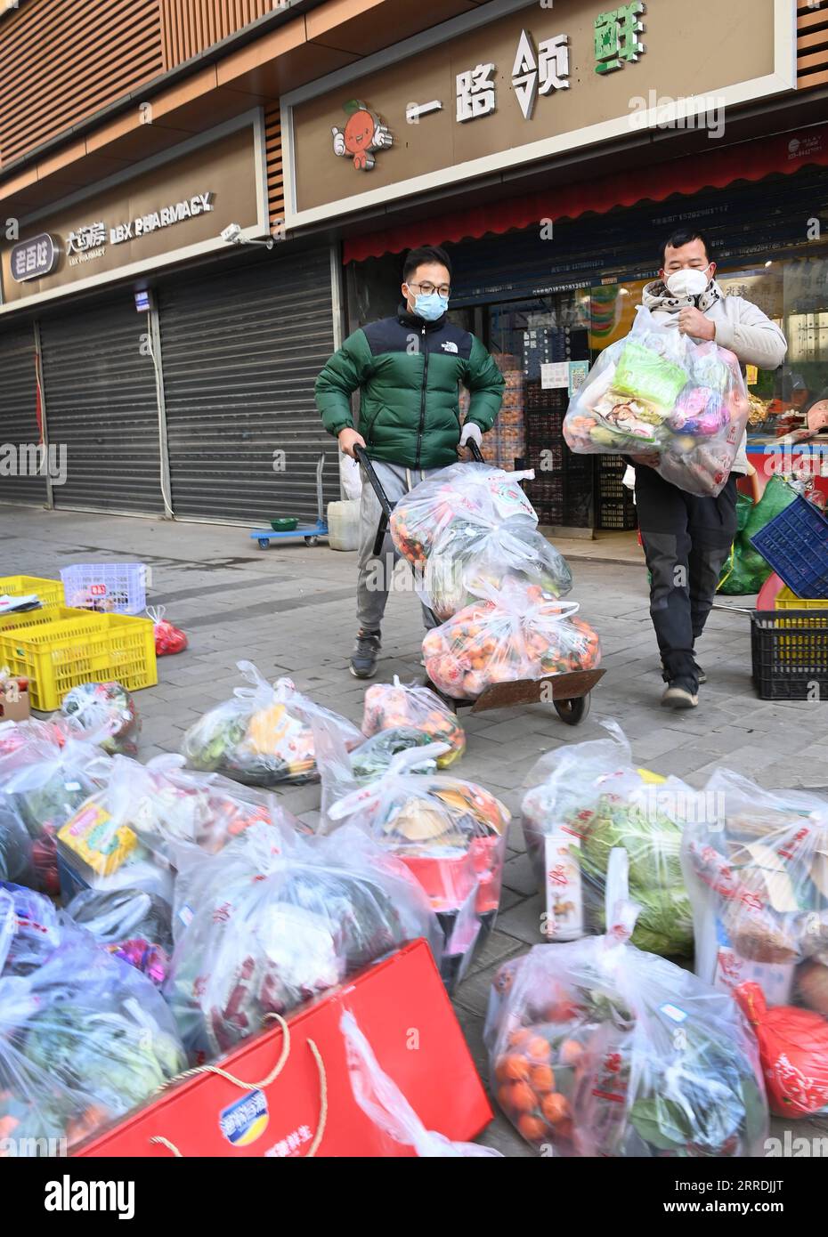 211229 -- XI AN, Dec. 29, 2021 -- Supermarket employees package vegetables to be delivered to households under closed-off management in Xi an, capital of northwest China s Shaanxi Province, Dec. 29, 2021. Authorities in Xi an have upgraded epidemic control and prevention measures starting Monday, ordering all residents to stay indoors and refrain from gatherings except when taking nucleic acid tests. Daily necessities of residents were guaranteed every day through delivery services.  CHINA-SHAANXI-XI AN-COVID-19-DAILY SUPPLIES DELIVERY CN TaoxMing PUBLICATIONxNOTxINxCHN Stock Photo