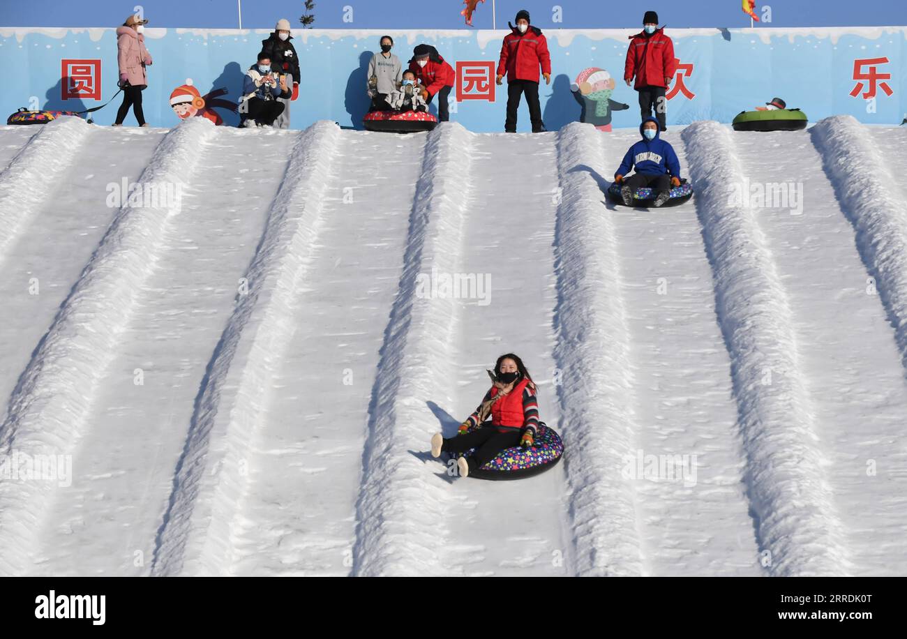 211230 -- BEIJING, Dec. 30, 2021 -- Visitors experience snow tubes at Yuanmingyuan Park in Beijing, capital of China, Dec. 30, 2021. The Old Summer Palace, or Yuanmingyuan, announced on Thursday that it will hold a ice and snow festival which opens around New Year s day in 2022 and lasts until February to welcome the Beijing 2022 Winter Olympic Games.  CHINA-BEIJING-YUANMINGYUAN PARK-WINTER FUN CN LuoxXiaoguang PUBLICATIONxNOTxINxCHN Stock Photo
