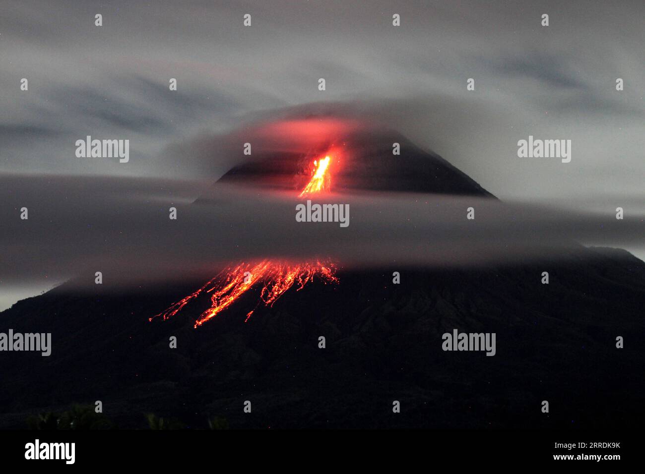 211231 -- MAGELANG, Dec. 31, 2021 -- Photo taken on Dec. 31, 2021 shows Mount Merapi spewing smoke and volcanic materials, as seen from Srumbung Village in Magelang, Central Java, Indonesia. Photo by /Xinhua INDONESIA-MAGELANG-MOUNT MERAPI-ERUPTION PriyoxUtomo PUBLICATIONxNOTxINxCHN Stock Photo