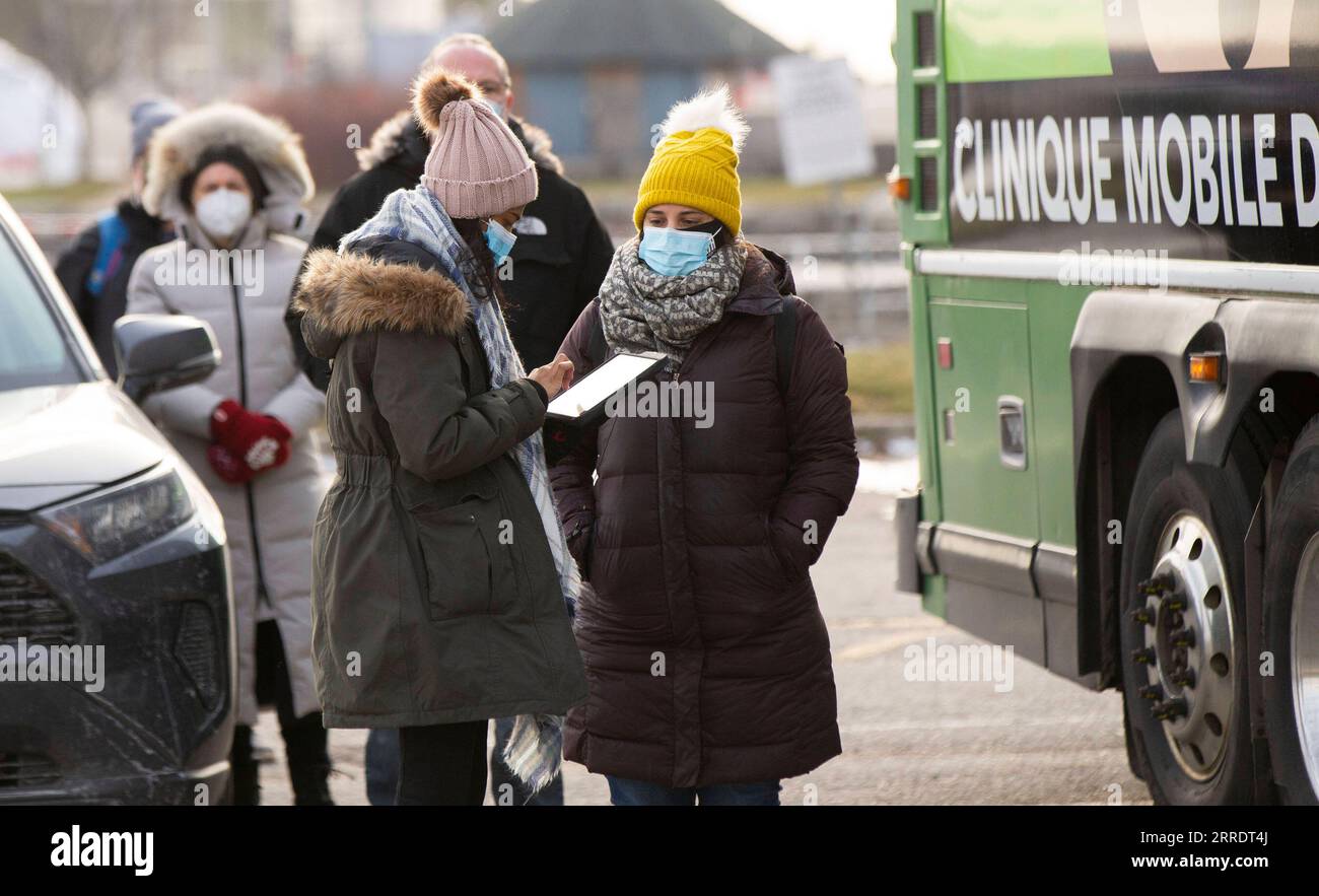 220106 -- TORONTO, Jan. 6, 2022 -- A staff member registers for people outside a mobile COVID-19 vaccination clinic in Toronto, Ontario, Canada, on Jan. 6, 2022. Canada s cumulative COVID-19 cases surpassed 2,400,000 as of Thursday morning, with the total hitting 2,408,013, including 30,544 deaths, according to CTV. Photo by /Xinhua CANADA-ONTARIO-COVID-19-CASES-2.4 MLN ZouxZheng PUBLICATIONxNOTxINxCHN Stock Photo