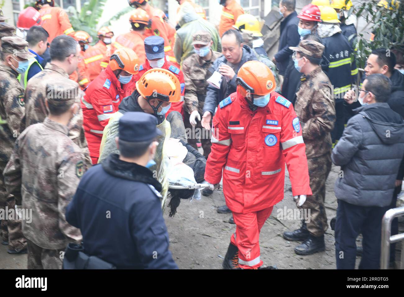 220107 -- CHONGQING, Jan. 7, 2022  -- Rescuers transport a trapped person at the site of a blast in Wulong District, southwest China s Chongqing, Jan. 7, 2022. More than 20 people were believed to have been trapped after a blast rocked a canteen of a subdistrict office in Wulong District, southwest China s Chongqing Municipality, on Friday noon. The accident took place at 12:10 p.m. due to suspected gas leakage which triggered the explosion and caused the collapse, said the municipal publicity department. According to witnesses, people were having lunch in the canteen when the blast took place Stock Photo