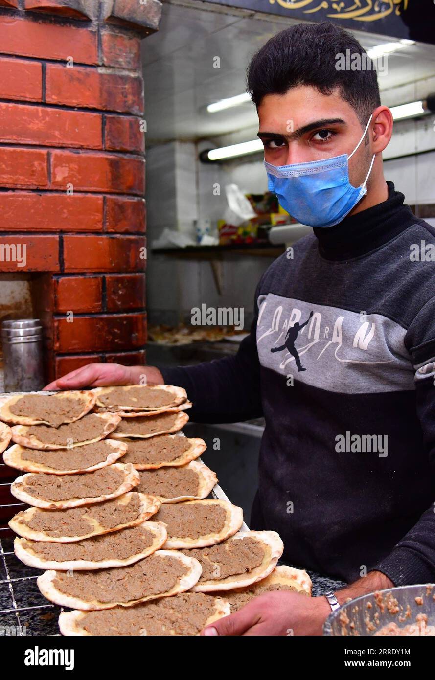 220113 -- DAMASCUS, Jan. 13, 2022 -- A baker presents Syrian traditional pastries in Damascus, Syria, Jan. 12, 2022. Photo by /Xinhua SYRIA-DAMASCUS-TRADITIONAL PASTRY AmmarxSafarjalani PUBLICATIONxNOTxINxCHN Stock Photo