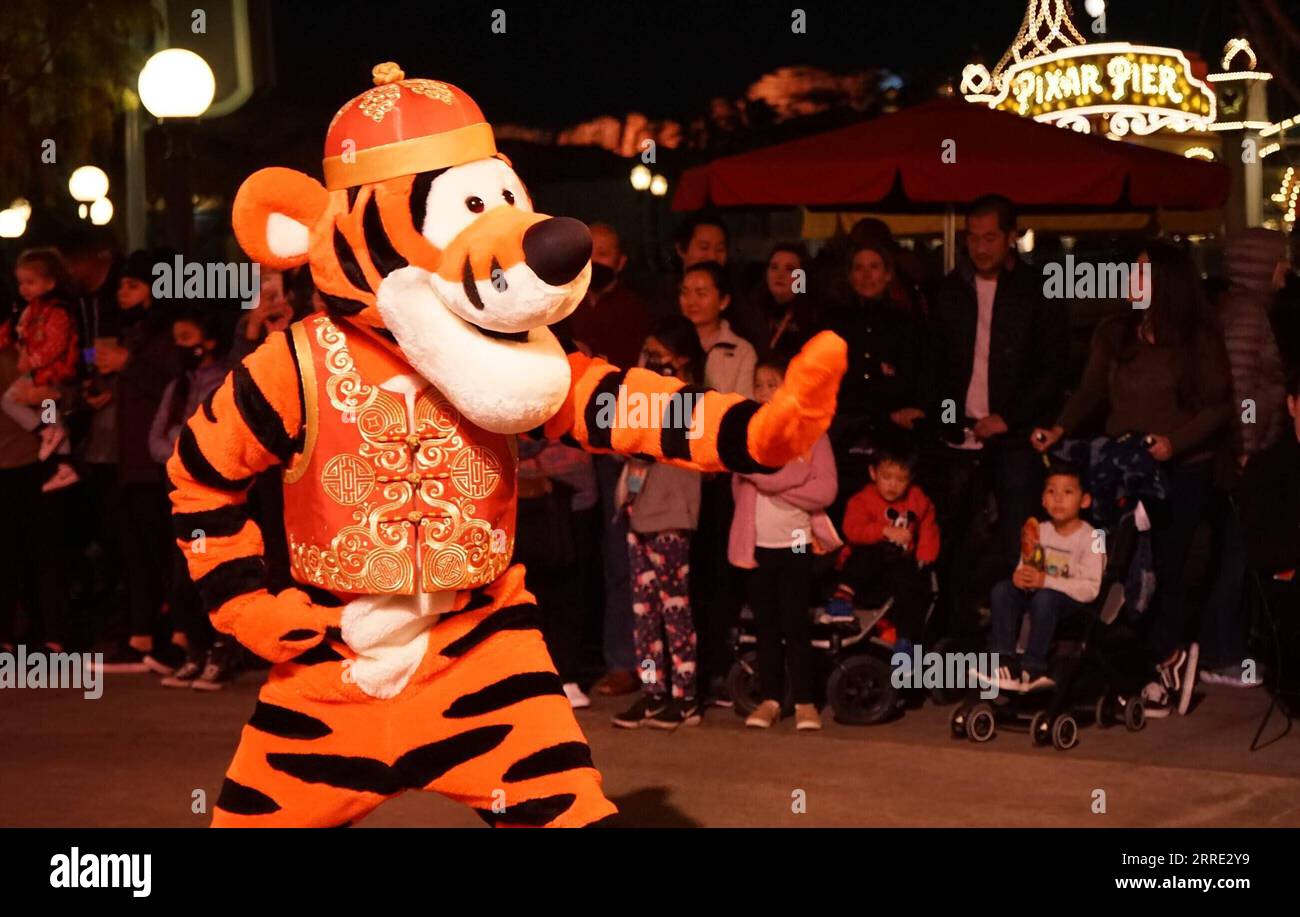220122 -- ANAHEIM U.S., Jan. 22, 2022 -- A person dressed as the cartoon character Tigger performs for visitors during the Lunar New Year celebrations at Disney s California Adventure Park in Anaheim, California, the United States, on Jan. 21, 2022. Disney s California Adventure Park kicked off celebrations of the Year of the Tiger Friday, featuring a string of Chinese culturally-themed performances, art shows, lantern decorations and Asian-inspired dishes. Photo by /Xinhua TO GO WITH Feature: Disneyland celebrates Chinese Lunar New Year with dynamic cultural activities U.S.-CALIFORNIA-ANAHEIM Stock Photo