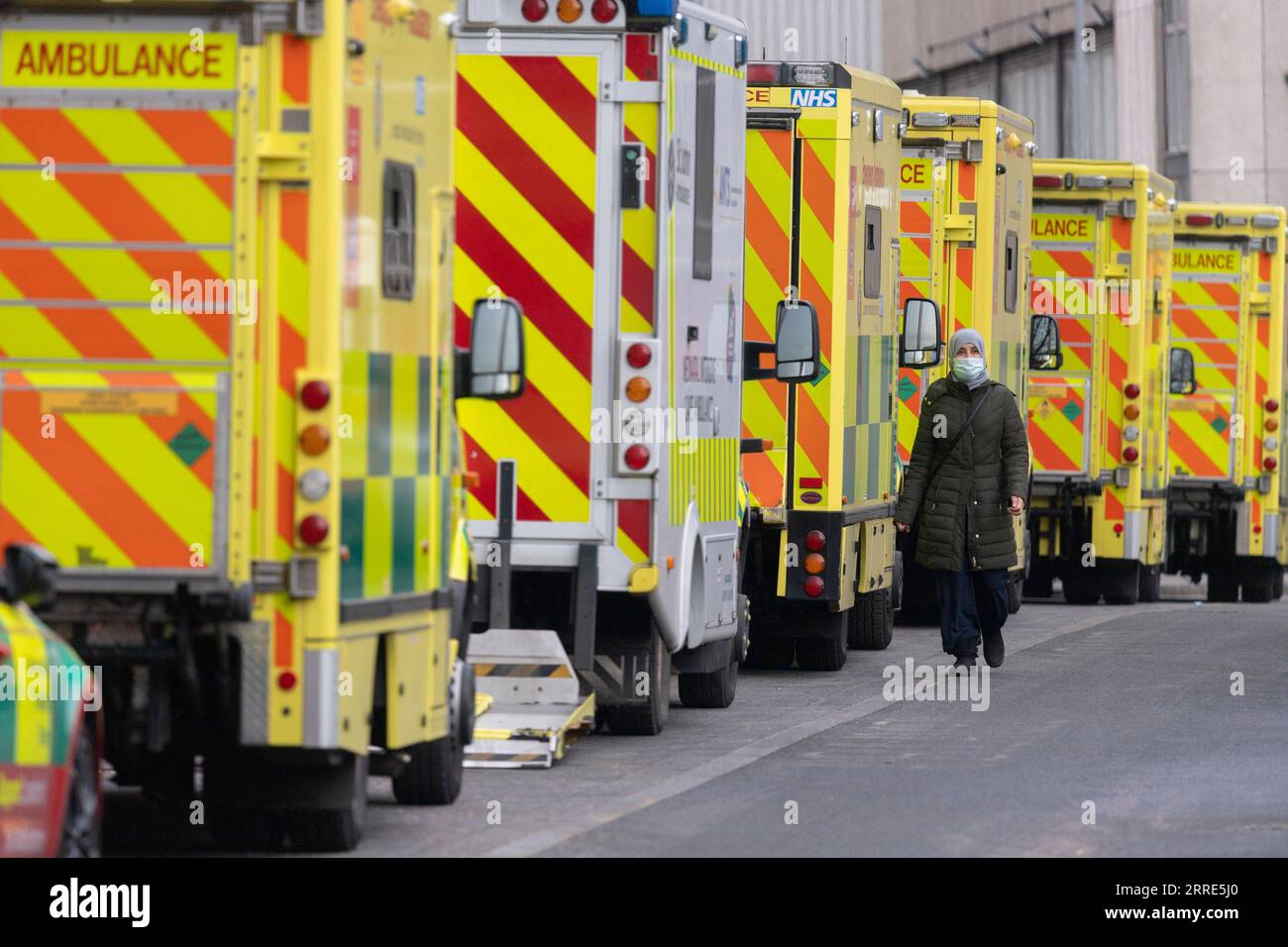220129 -- LONDON, Jan. 29, 2022 -- Photo taken on Jan. 28, 2022 shows a woman walking past ambulances parked outside the Royal London Hospital in London, Britain. A new form of Omicron named BA.2 has been designated a variant under investigation, with 426 cases of the Omicron variant sub-lineage confirmed in the United Kingdom UK, the UK Health Security Agency UKHSA said Friday. Photo by /Xinhua BRITAIN-LONDON-COVID-19-OMICRON RayxTang PUBLICATIONxNOTxINxCHN Stock Photo