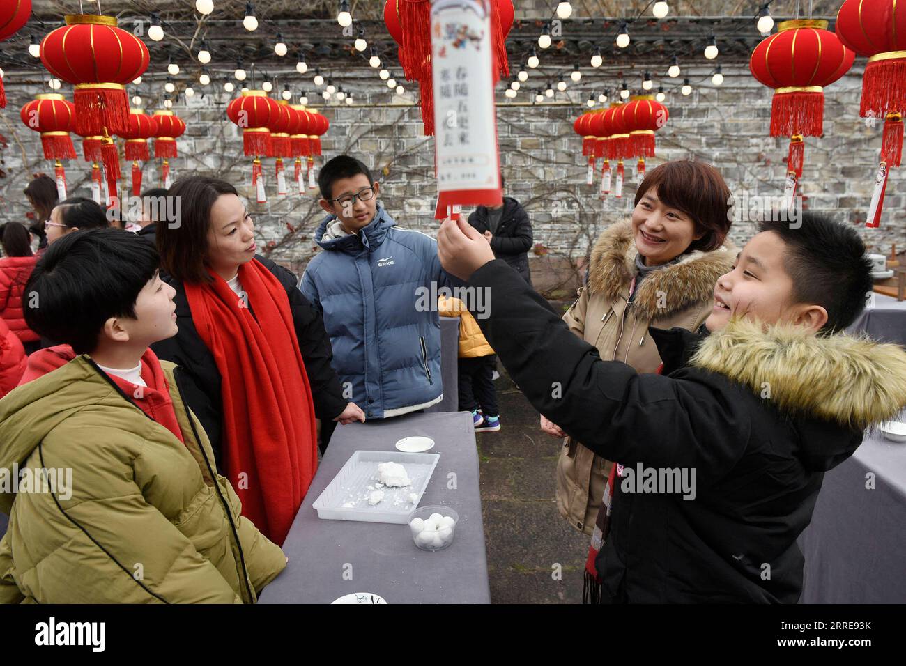 220210 -- NINGBO, Feb. 10, 2022 -- Children and their parents guess riddles in Zhenhai District of Ningbo, east China s Zhejiang Province, Feb. 10, 2022. Various events are held across China to celebrate the upcoming Lantern Festival. Photo by /Xinhua CHINA-LANTERN FESTIVAL-CELEBRATION CN HuxXuejun PUBLICATIONxNOTxINxCHN Stock Photo