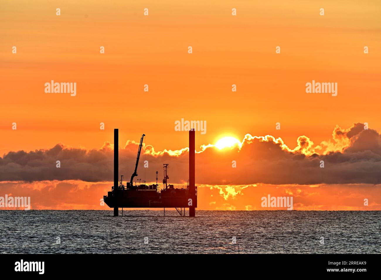 Drilling test rig ARAN250 jackup with gold rimmed horizon cloud orange ...