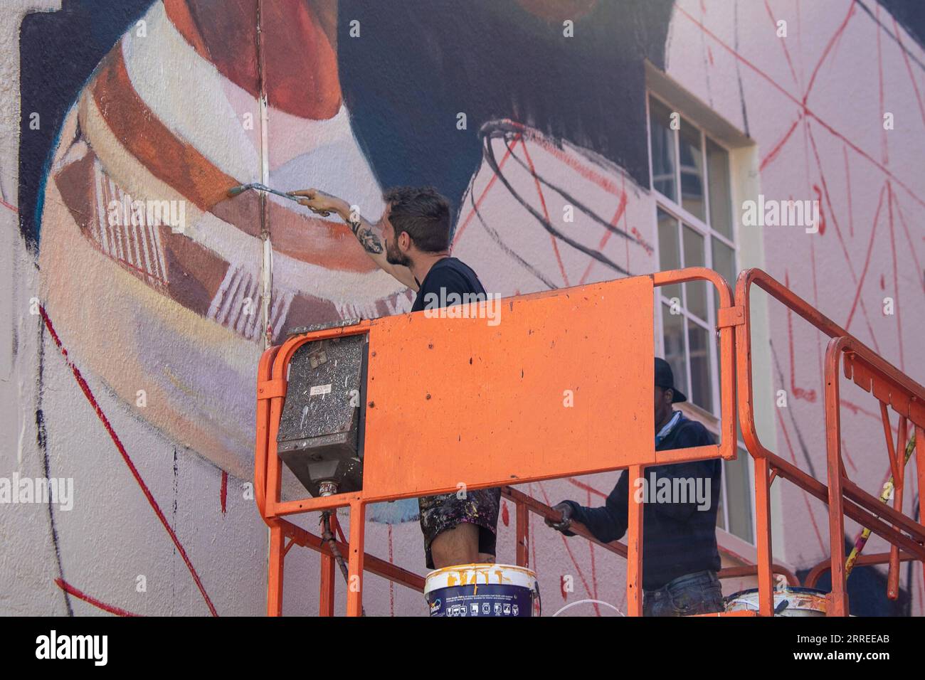 220223 -- CAPE TOWN, Feb. 23, 2022 -- Artists work on a mural for the International Public Arts Festival in Cape Town, South Africa, on Feb. 23, 2022. The sixth edition of the International Public Arts Festival, Africa s largest street art festival, is held from Wednesday to Sunday in Cape Town, with new large murals to beautify walls in the central business district.  SOUTH AFRICA-CAPE TOWN-STREET ART FESTIVAL LyuxTianran PUBLICATIONxNOTxINxCHN Stock Photo