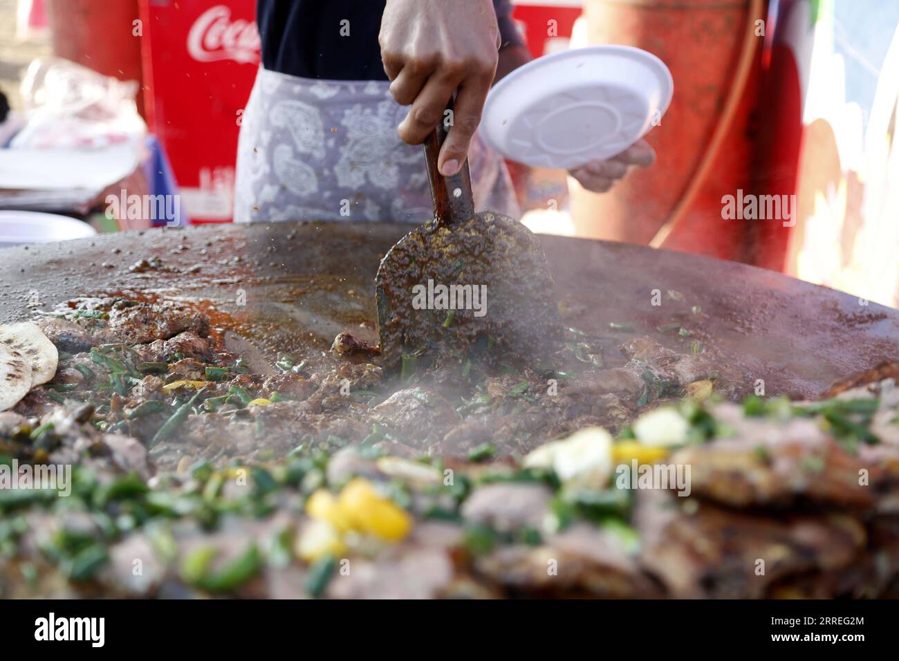 220227 -- ISLAMABAD, Feb. 27, 2022 -- A chef prepares food during Islamabad Eat food festival in Islamabad, capital of Pakistan, Feb. 26, 2022. Islamabad Eat, a famous food festival of the Pakistani capital, returned to the city in its true spirit, after a two-year absence induced by the outbreak of COVID-19, which halted many other excursion and sports activities in the country besides the festival.  PAKISTAN-ISLAMABAD-COVID-19-FOOD FESTIVAL AhmadxKamal PUBLICATIONxNOTxINxCHN Stock Photo