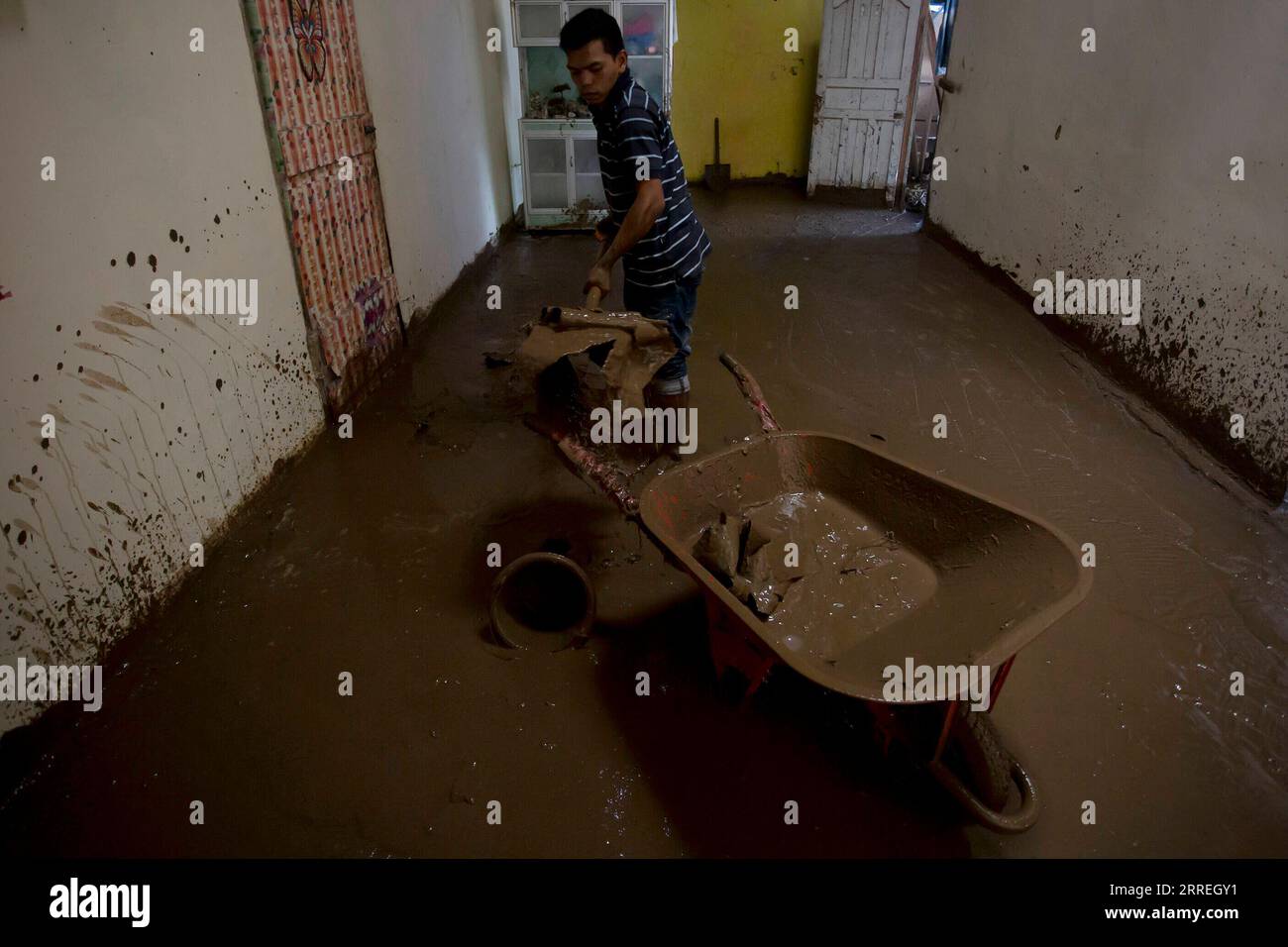 220301 -- WEST SUMATRA, March 1, 2022 -- A man cleans mud at his house after floods triggered by heavy rains and rising waters of the Batang Nango river after a 6.1-magnitude quake in Nagari Kajai village of Pasaman Barat district, West Sumatra, Indonesia, March 1, 2022. Photo by /Xinhua INDONESIA-WEST SUMATRA-FLOOD-AFTERMATH AndrixMardiansyah PUBLICATIONxNOTxINxCHN Stock Photo