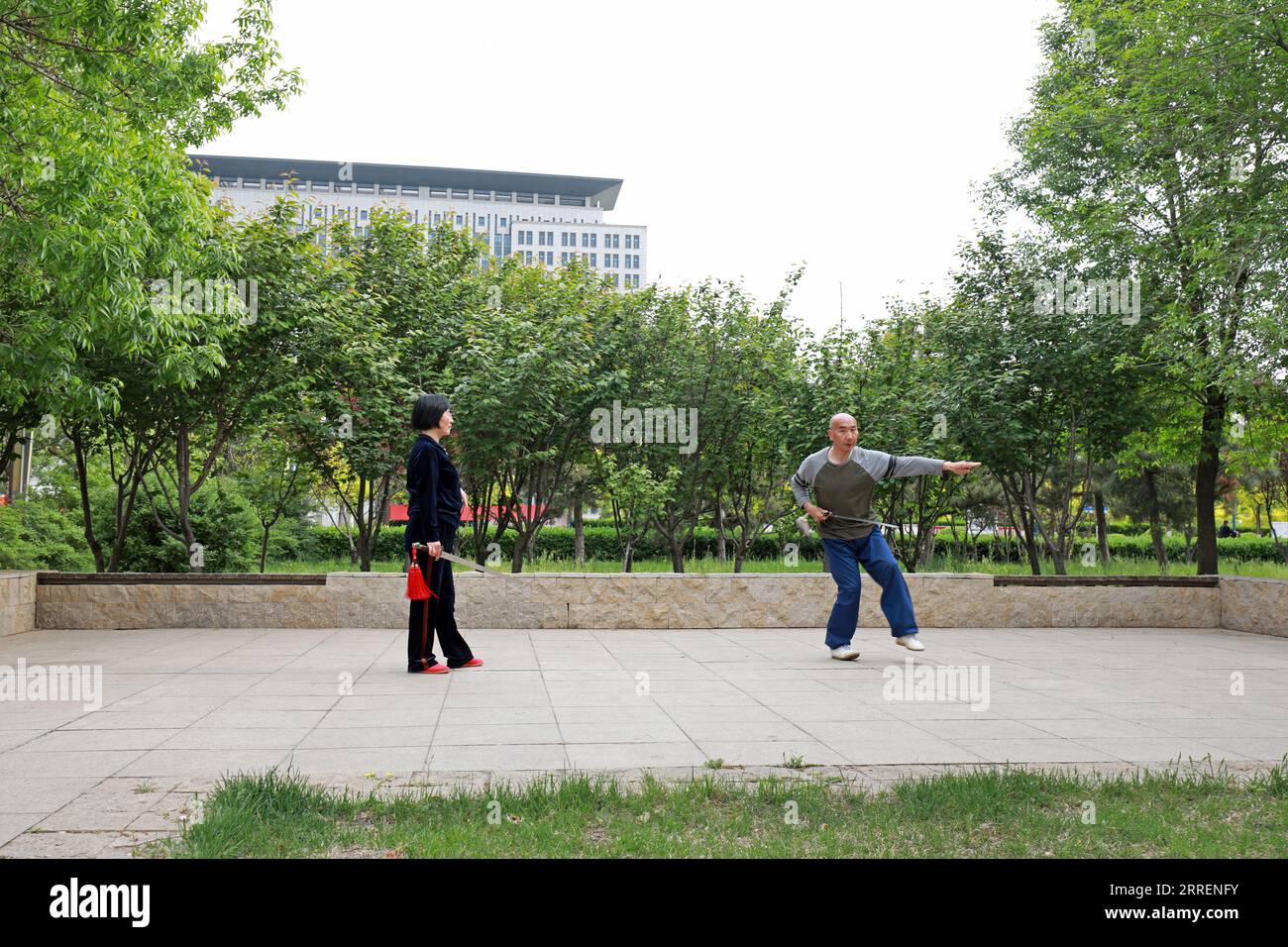 LUANNAN COUNTY, Hebei Province, China - May 4, 2020: two people practice Taiji sword in a park. Stock Photo