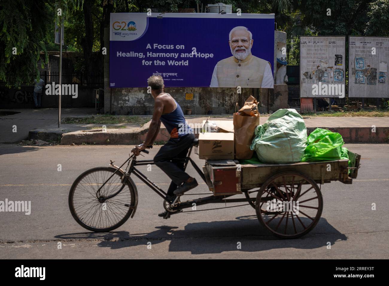 A man rides a cycle rickshaw past a billboard featuring Indian Prime ...