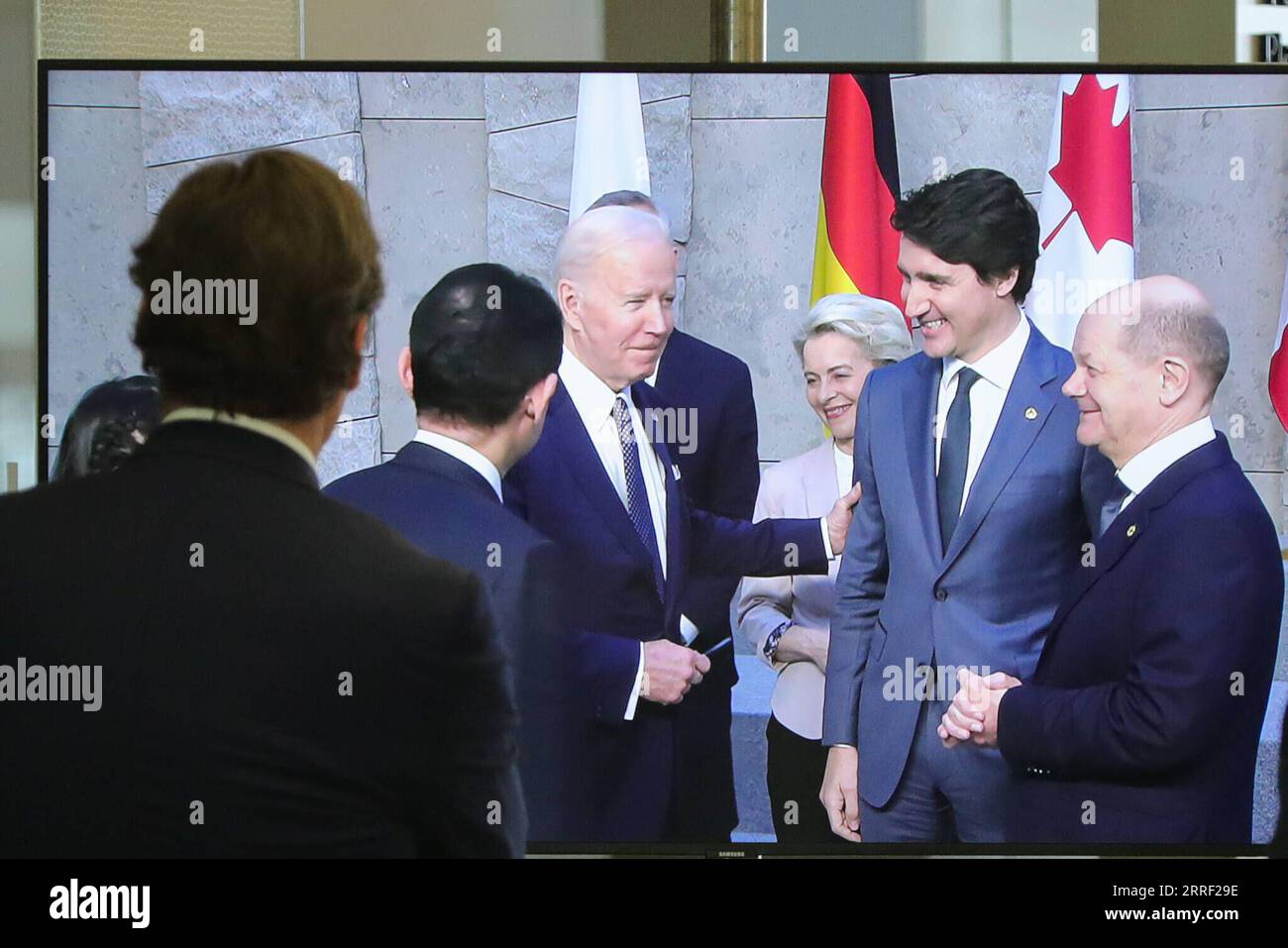 220324 -- BRUSSELS, March 24, 2022 -- A man watches a screen displaying U.S. President Joe Biden 4th R, President of the European Commission Ursula von der Leyen 3rd R, Canadian Prime Minister Justin Trudeau 2nd R and German Chancellor Olaf Scholz 1st R attending a photo session during a meeting of G7 Leaders at the NATO headquarters in Brussels, Belgium, March 24, 2022.  BELGIUM-BRUSSELS-G7-MEETING ZhengxHuansong PUBLICATIONxNOTxINxCHN Stock Photo
