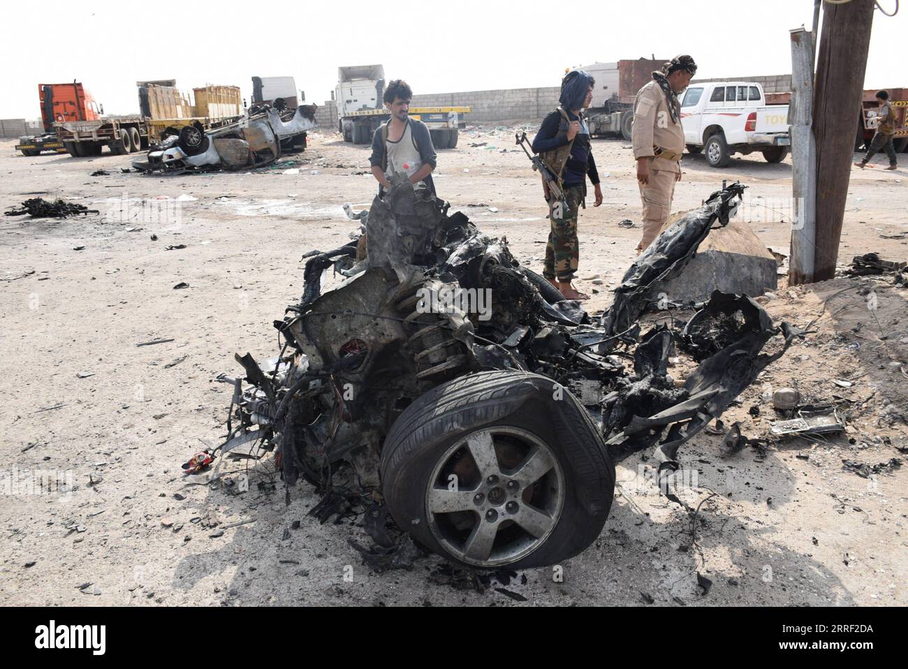 News Bilder des Tages 220325 -- ADEN, March 25, 2022 -- Security officers stand next to the wreckage of a car on a street of Aden, the southern port city of Yemen, on March 24, 2022. A deadly booby trap bomb attack in southern Yemen s Aden killed a high-ranking military commander of the Yemeni army and three bodyguards on Wednesday, a government official told Xinhua. Photo by /Xinhua YEMEN-ADEN-SENIOR COMMANDER-KILLED MuradxAbdo PUBLICATIONxNOTxINxCHN Stock Photo