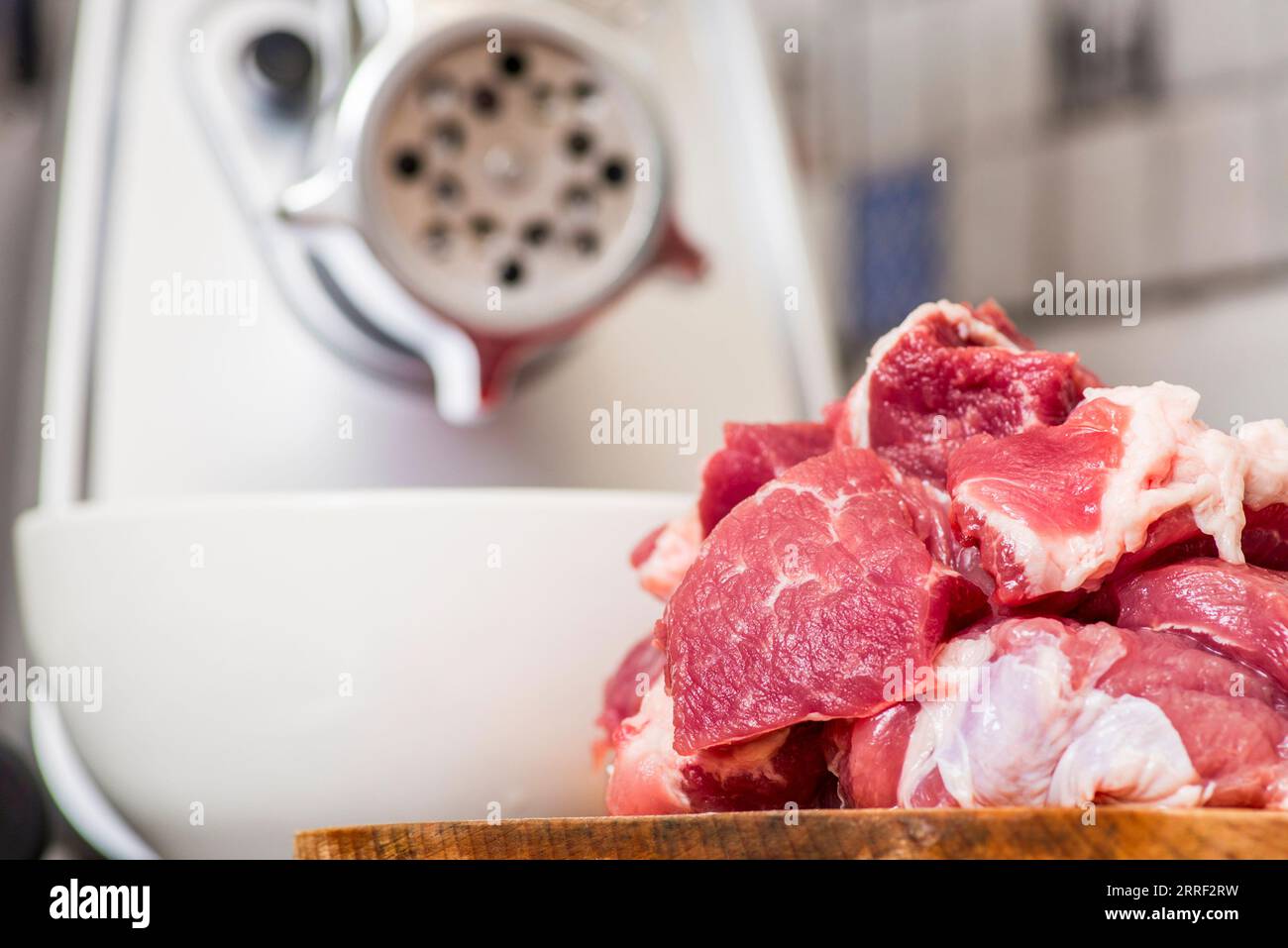 https://c8.alamy.com/comp/2RRF2RW/meat-grinder-with-fresh-meat-on-a-cutting-board-in-kitchen-interior-2RRF2RW.jpg