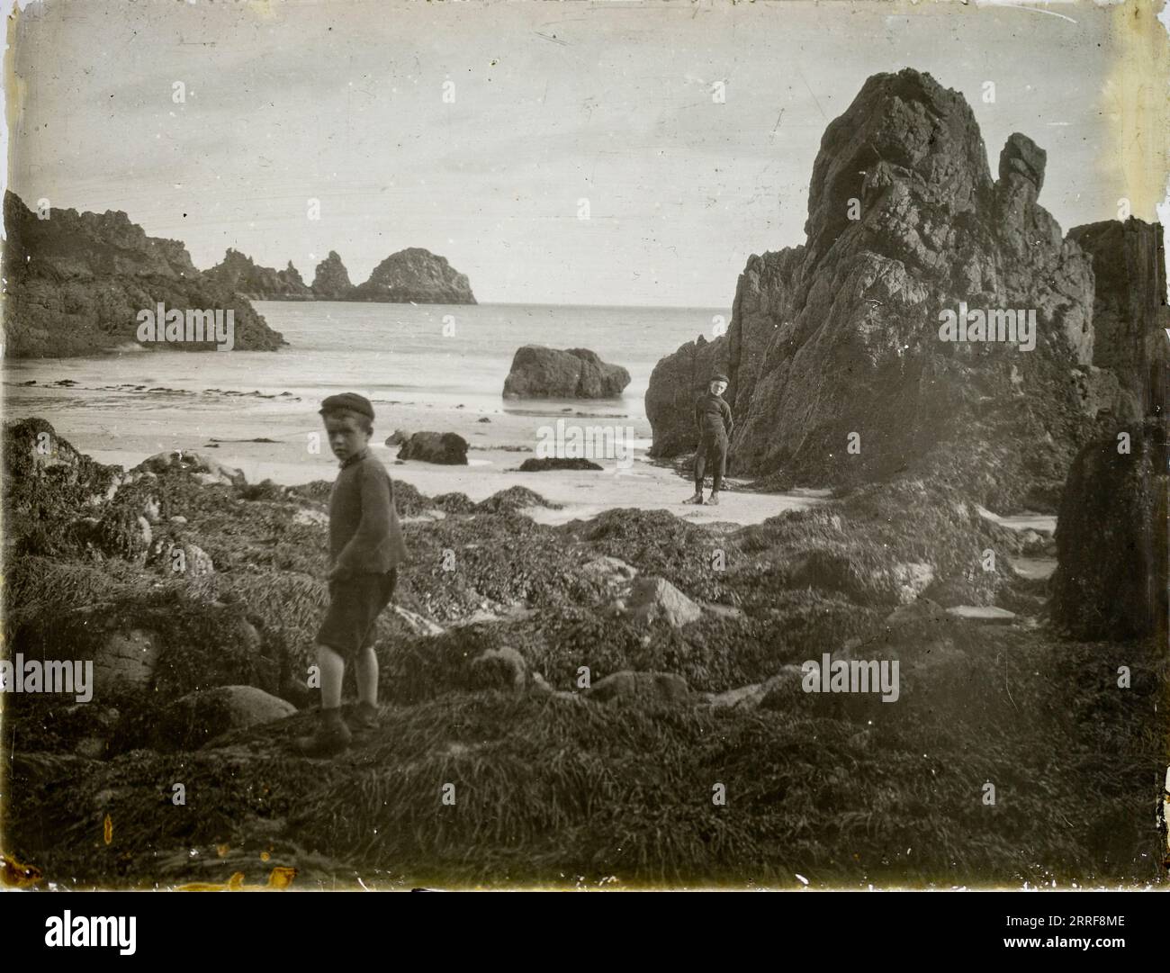 Magic lantern slide two boys playing on rocky beach circa 1900 location not known, presumed to be England, UK perhaps Cornwall Stock Photo