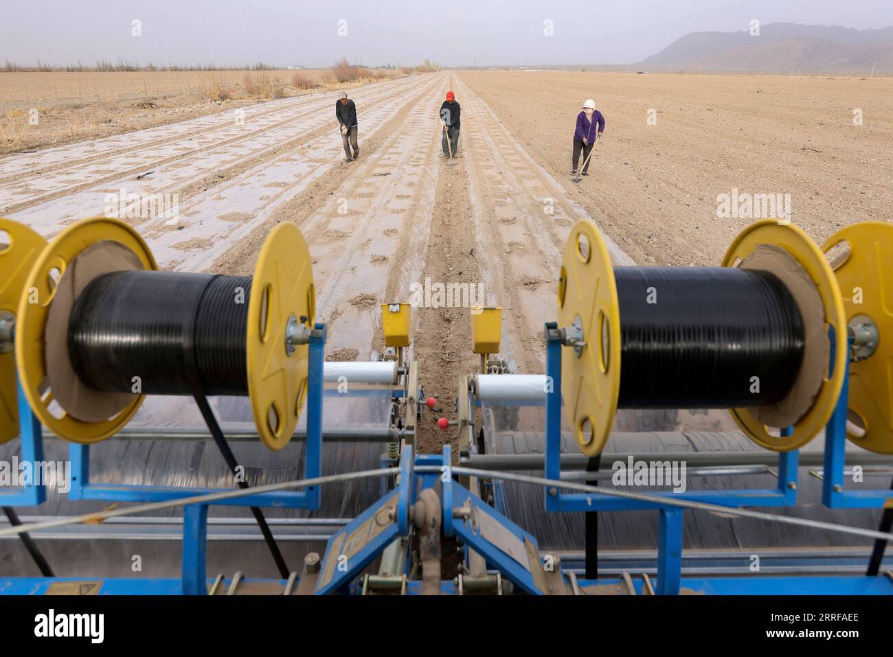 220409-urumqi-april-9-2022-farmers-cover-fields-with-plastic