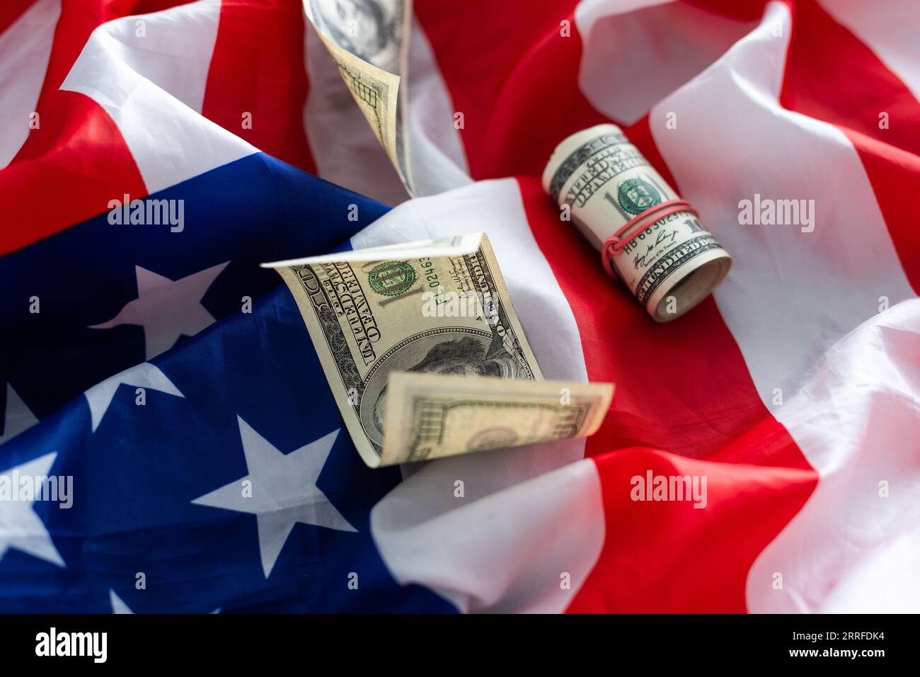 American striped flag and a stack of one hundred dollar bills ...