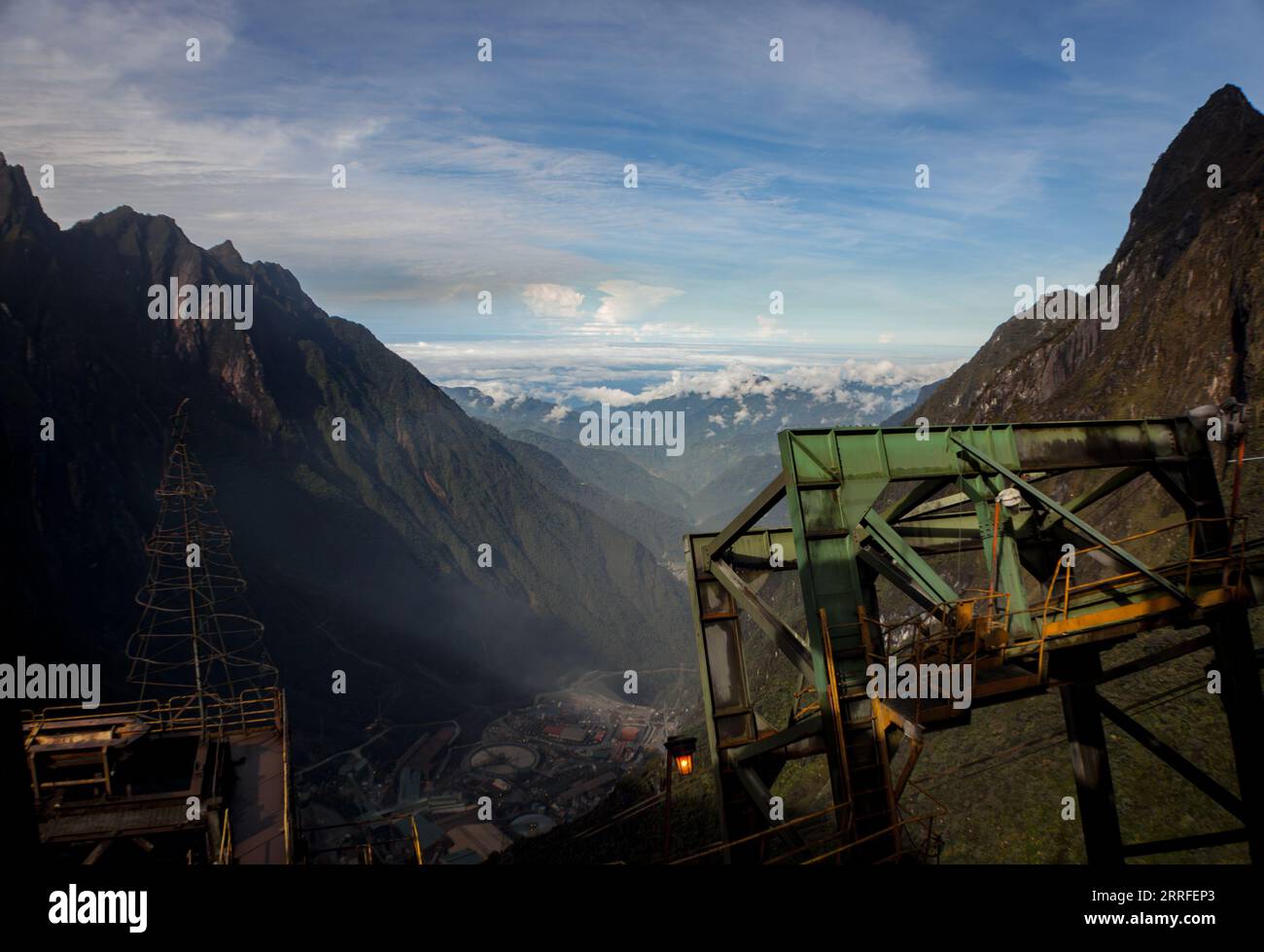 The massive infrastructure from above the mill with a view of the cable car equipment surrounded by mountains Stock Photo