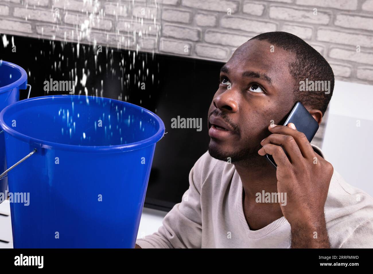 Couple Using Bucket For Collecting Water Leakage From Ceiling And