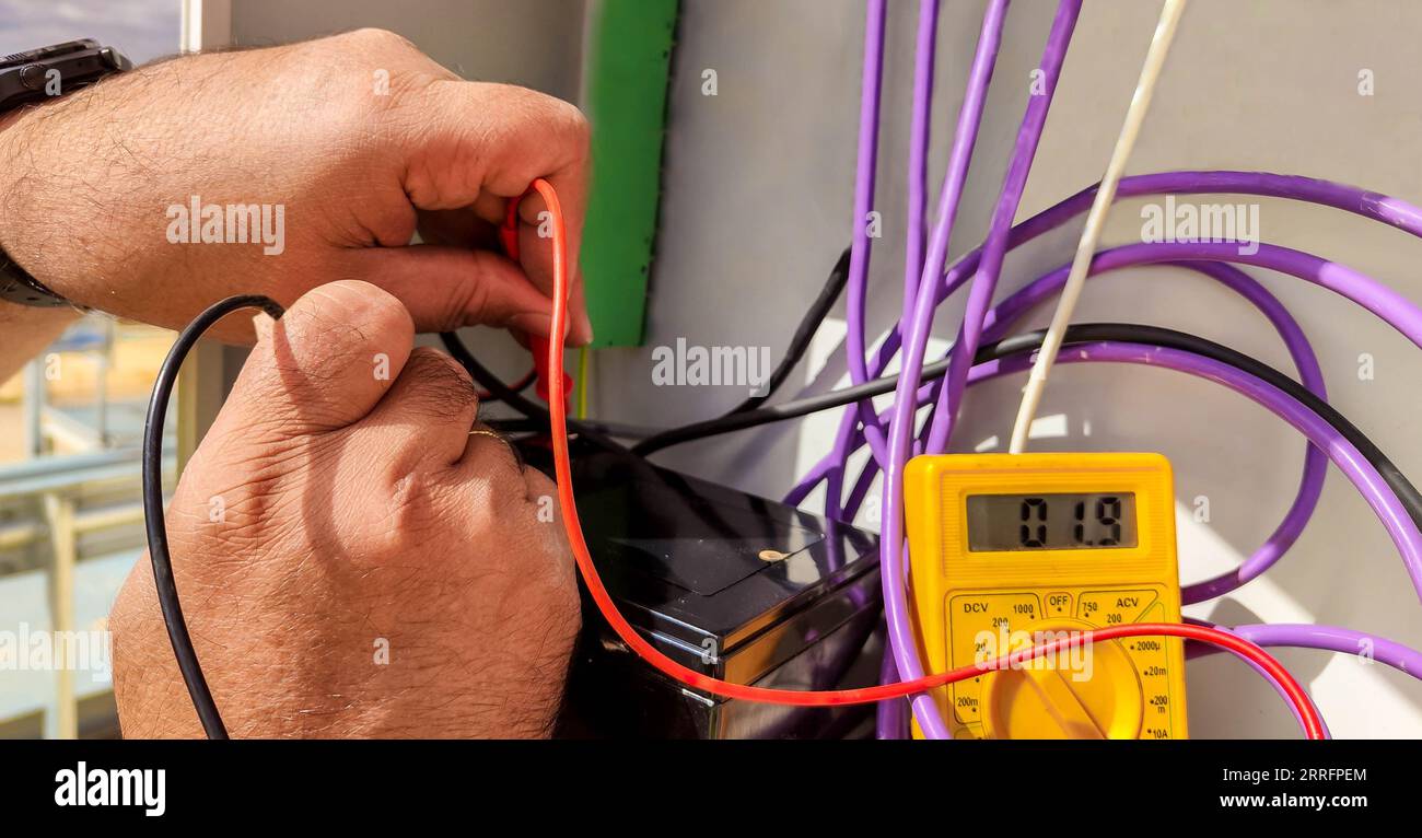 hands of an electrical technician checking with a polymeter the voltage and the correct installation of the equipment Stock Photo