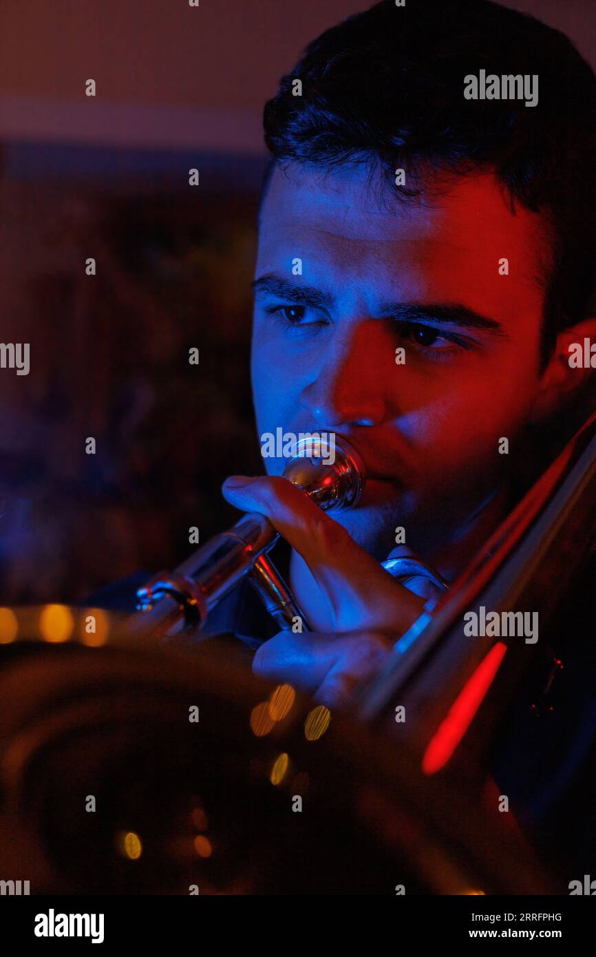 boy playing jazz trombone with red and blue lights Stock Photo Alamy