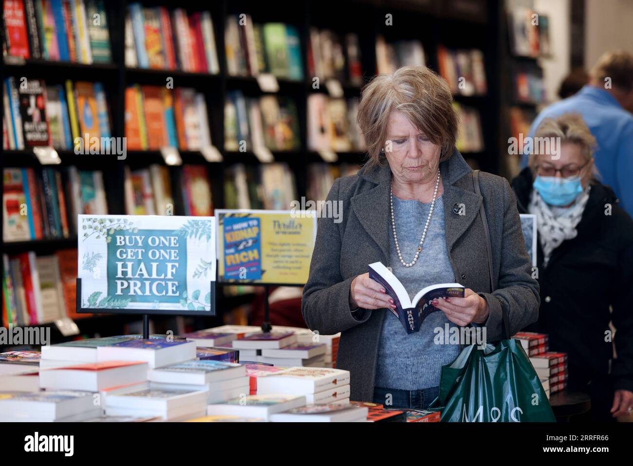 220424 -- STRATFORD UPON AVON, April 24, 2022 -- A woman reads in a bookstore in Stratford-upon-Avon, Britain, April 23, 2022. Over 1,000 people gathered at Stratford-upon-Avon, the hometown of William Shakespeare, to celebrate the British playwright s 458th birthday on Saturday.  BRITAIN-STRATFORD UPON AVON-SHAKESPEARE-CELEBRATION LixYing PUBLICATIONxNOTxINxCHN Stock Photo