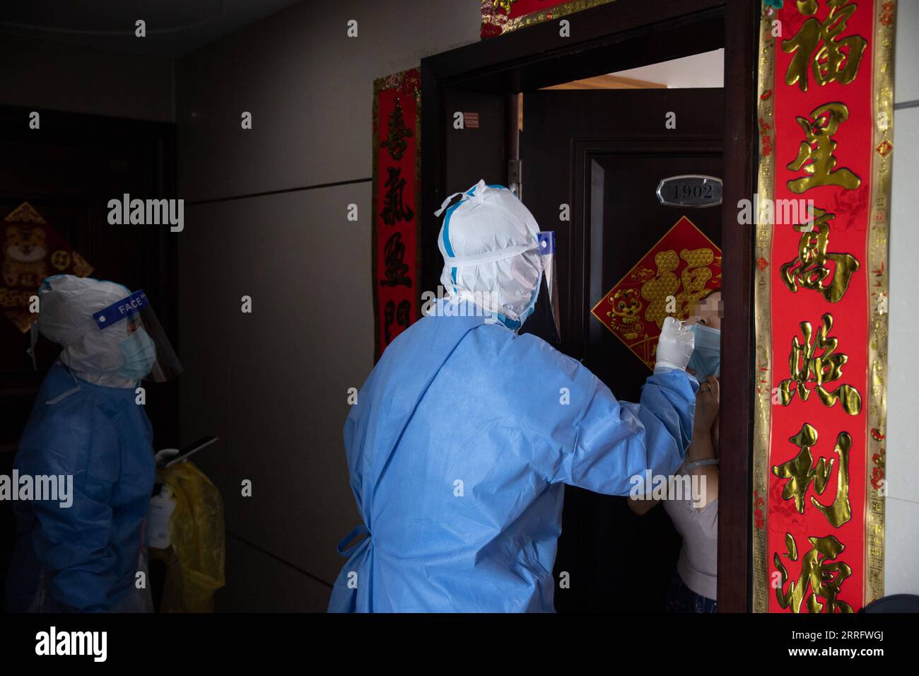 220427 -- SHANGHAI, April 27, 2022 -- Tian Ge C takes a swab sample from a resident for nucleic acid test at a building under closed-off management in Beicai Town of east China s Shanghai, April 26, 2022. Tian Ge and He Yanping, both general practitioners, conduct a door-to-door nucleic acid test for residents without negative results in mass testing or antigen testing in Beicai.  CHINA-SHANGHAI-BEICAI-NUCLEIC ACID TEST CN JinxLiwang PUBLICATIONxNOTxINxCHN Stock Photo